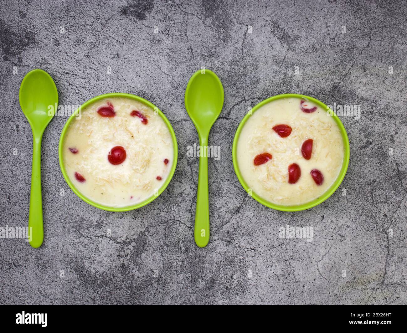 Sewai o kheer consumati in occasione di festival eid o indiani. Servito con condimenti di ciliegia rossa in una ciotola verde. Foto Stock