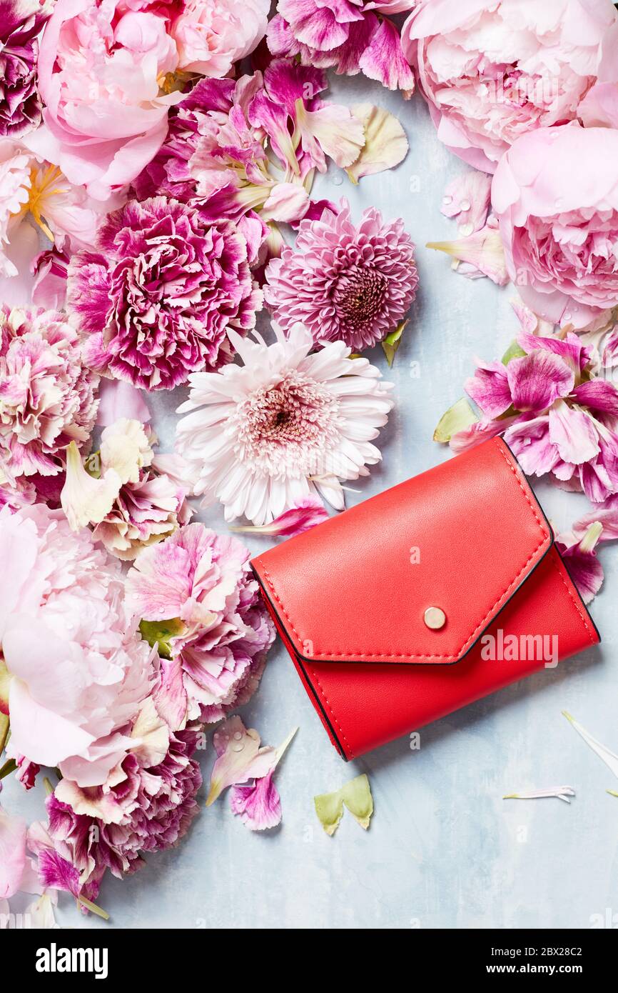 Vita morta della borsetta rossa e dei pedali dei fiori Foto stock - Alamy