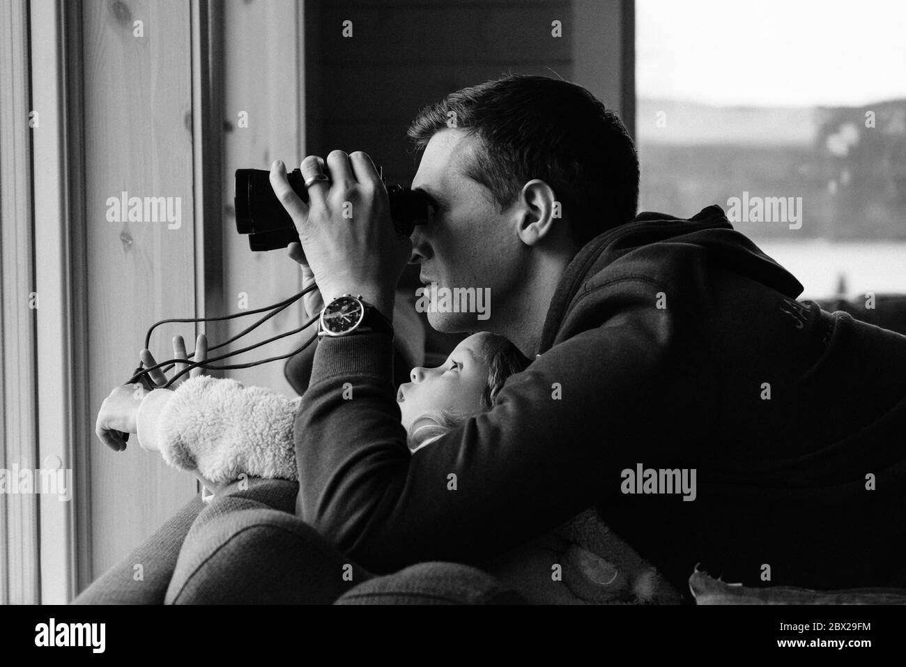 padre e figlia che guardano attraverso il binocolo alla natura all'esterno Foto Stock