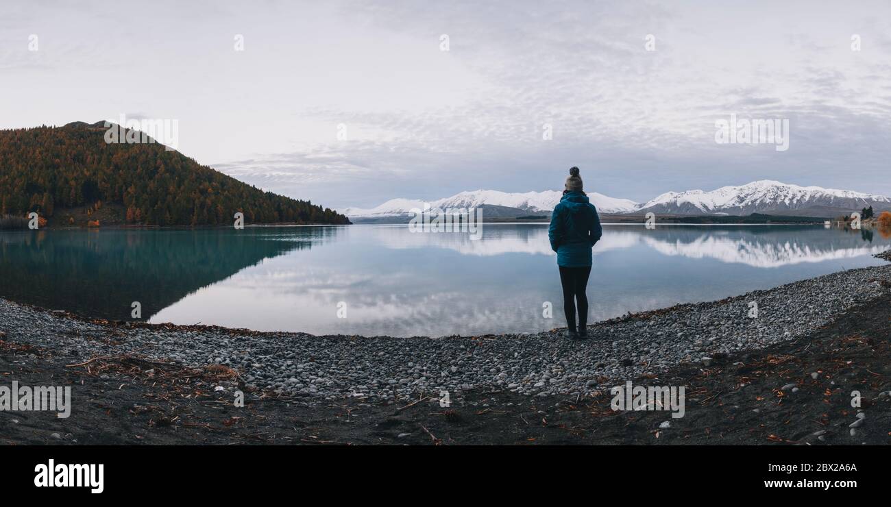 Giovane donna si trova di fronte al lago Tekapo e alle Alpi meridionali Foto Stock