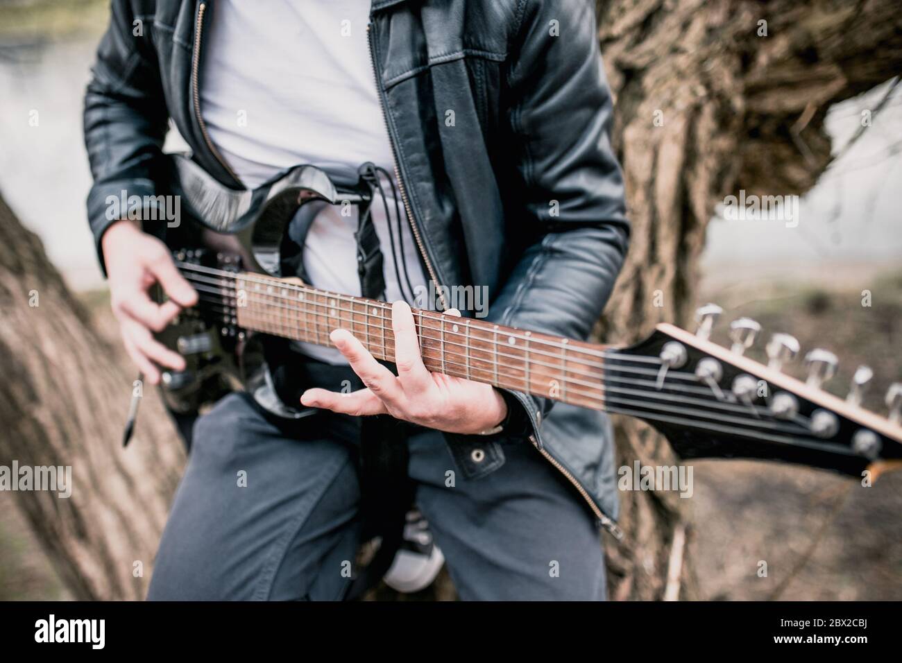 Tecnica di suonare la chitarra elettrica - un uomo che suona all'aperto - musica rock pesante e blues Foto Stock