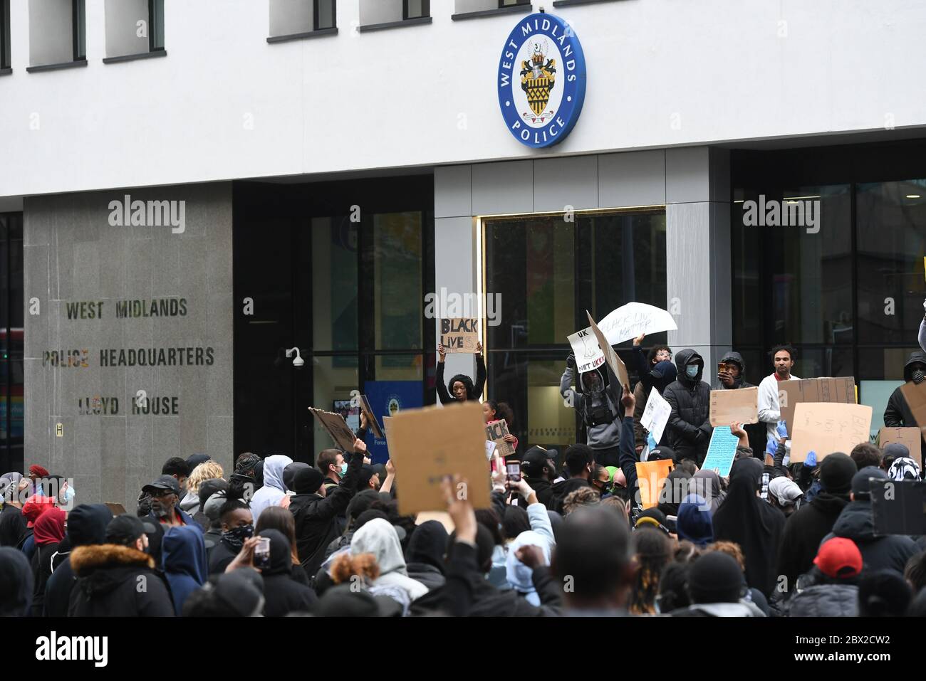 Persone che protestano fuori dal quartier generale della polizia delle West Midlands, Colmore Circus, durante un raduno di protesta contro la Black Lives Matter a Birmingham, in memoria di George Floyd, ucciso il 25 maggio mentre era in custodia di polizia nella città americana di Minneapolis. Foto Stock