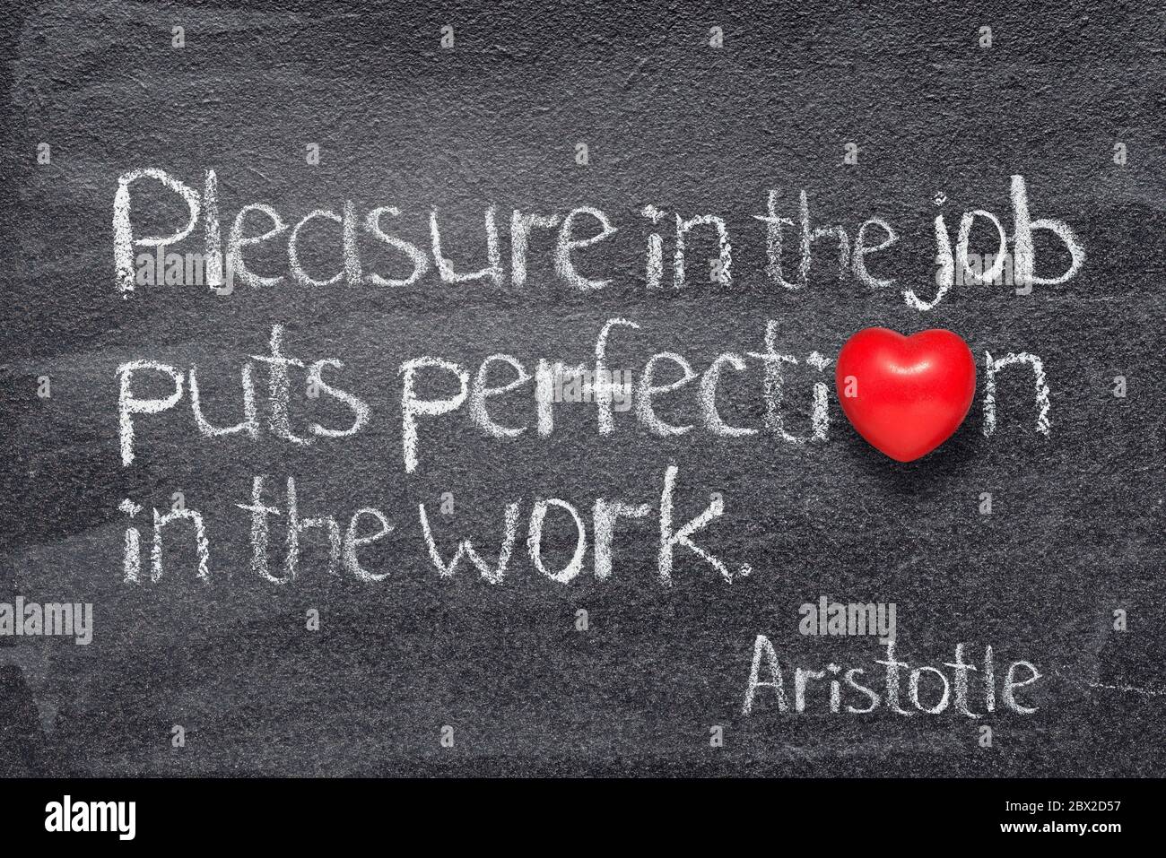 Il piacere nel lavoro mette la perfezione nel lavoro - citazione del filosofo greco antico Aristotele scritto su lavagna con cuore rosso invece di o Foto Stock