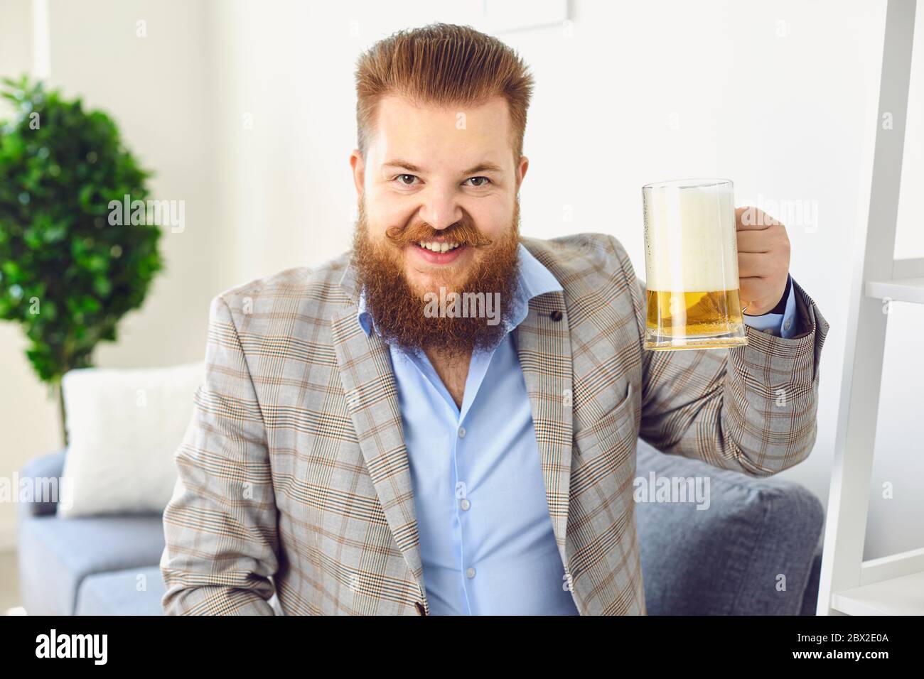 Guardare la fotocamera online. Divertente uomo con un bicchiere di birra sorride agli amici online video chat call webcam conferenza home applicazione. Foto Stock