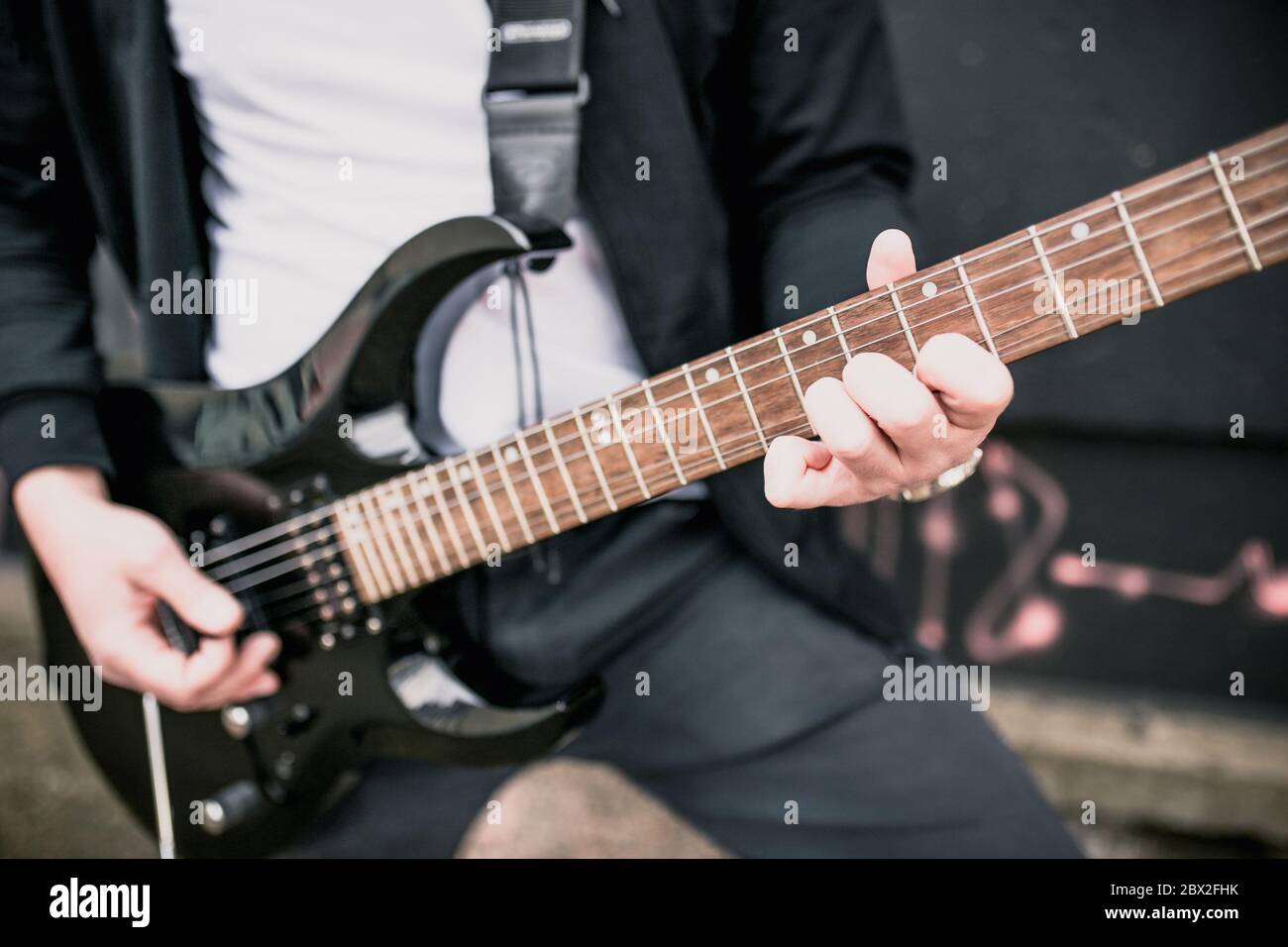 Uomo con una chitarra elettrica nera all'aperto - musica rock blues Foto Stock