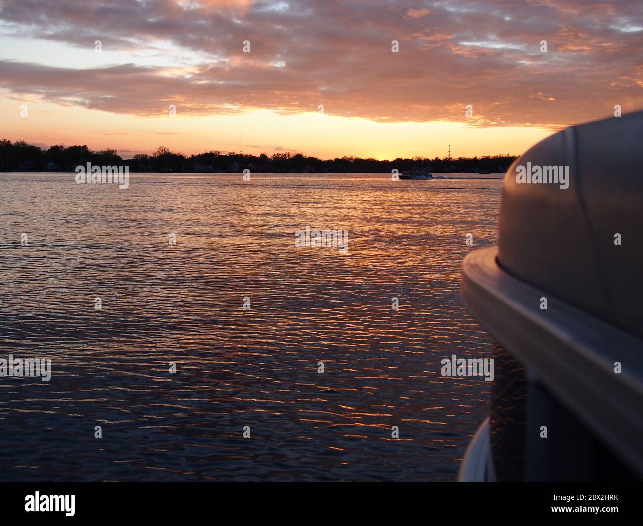 Tramonto sul lago che riflette sulla barca Pontoon Foto Stock