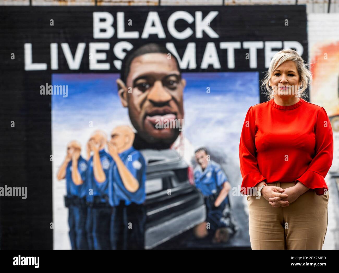 NOTA IL CONTENUTO DEL MURALE Vice primo Ministro dell'Irlanda del Nord Michelle o'Neill visita il Muro Internazionale di Belfast per vedere il murale appena dipinto a George Floyd. Il signor Floyd è morto dopo che un ufficiale bianco lo ha tenuto giù premendo un ginocchio nel suo collo lunedì scorso. Il murale fu commissionato da Feile an Phobail e Failte Feirste Thiar, e dipinto da Marty Lyons e Mickey Doherty. Foto Stock