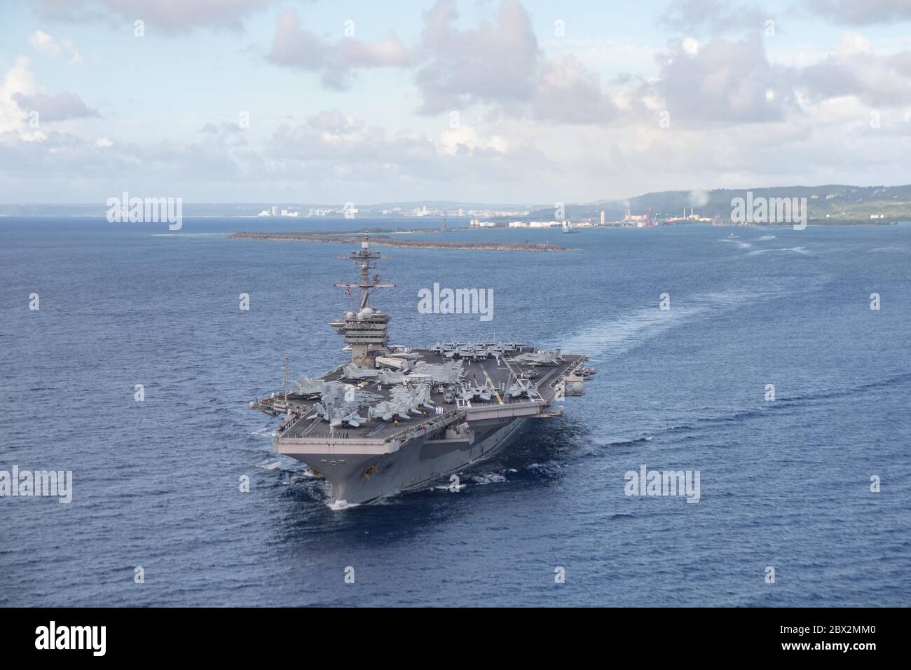 Apra Harbour, Stati Uniti. 04giugno 2020. La portaerei della marina statunitense di classe Nimitz USS Theodore Roosevelt si dirige verso acque profonde, mentre parte alla base navale Guam 4 giugno 2020 ad Apra Harbour, Guam. La nave ha completato le qualifiche del vettore in seguito ad una quarantena di equipaggio infetto da COVID ed è ora pronta per continuare lo schieramento alla settima flotta. Credito: MCS Kaylianna Genier/USA Notizie dal vivo sulla Marina/Alamy Foto Stock