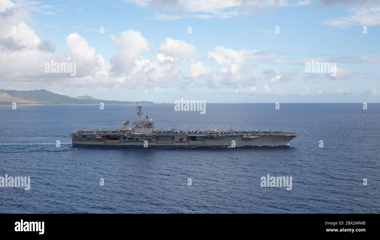 Apra Harbour, Stati Uniti. 04giugno 2020. La portaerei della marina statunitense di classe Nimitz USS Theodore Roosevelt si dirige verso acque profonde, mentre parte alla base navale Guam 4 giugno 2020 ad Apra Harbour, Guam. La nave ha completato le qualifiche del vettore in seguito ad una quarantena di equipaggio infetto da COVID ed è ora pronta per continuare lo schieramento alla settima flotta. Credito: MCS Kaylianna Genier/USA Notizie dal vivo sulla Marina/Alamy Foto Stock