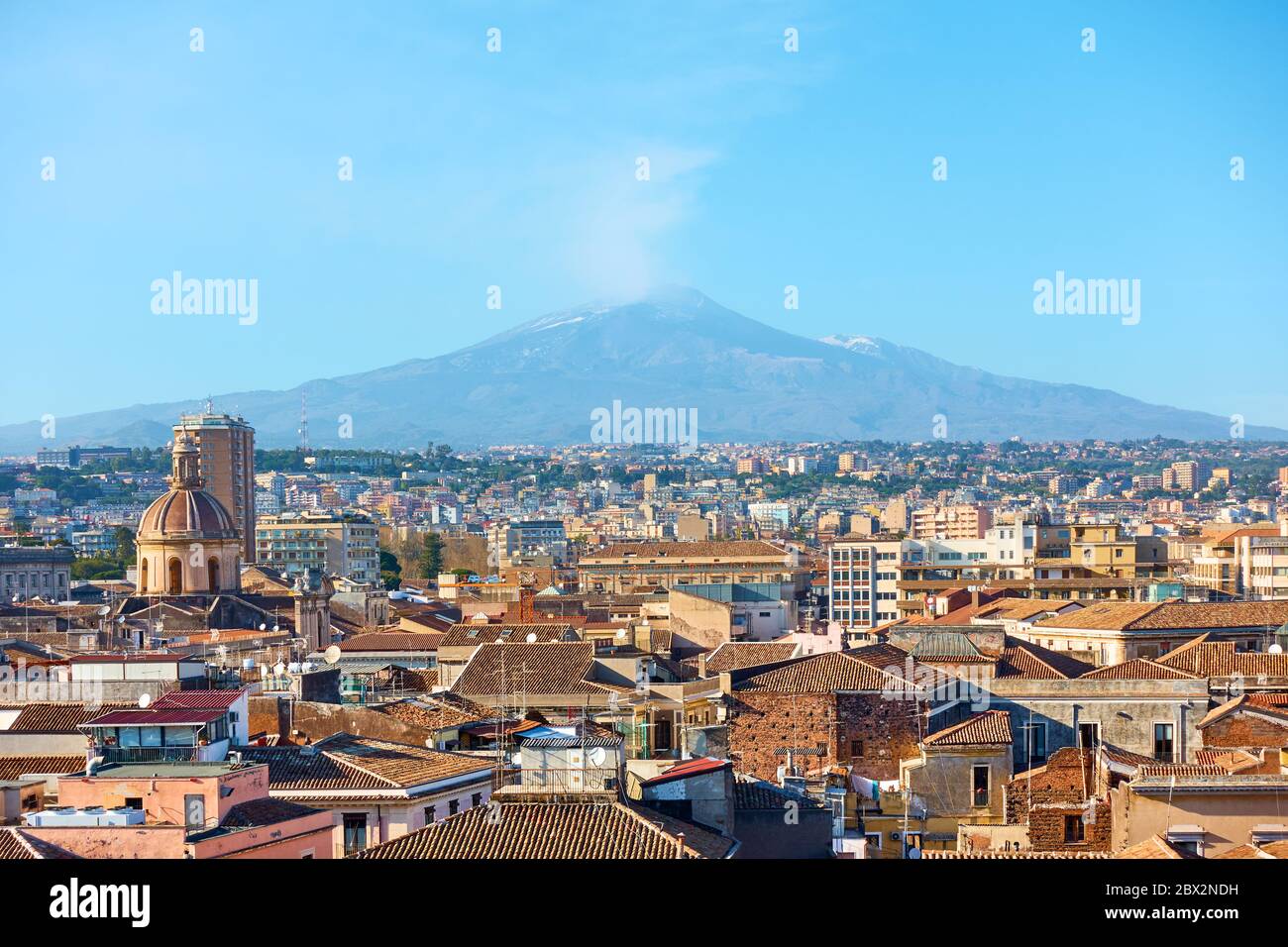 Tetti del centro storico di Catania e il vulcano Etna fumante, Sicilia, Italia Foto Stock
