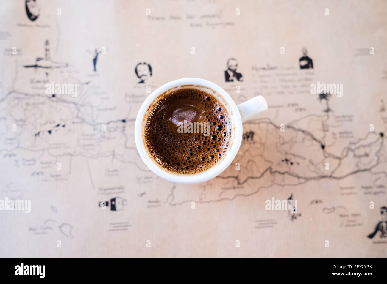 Top Down immagine del caffè greco su un tavolo con una mappa di Creta Foto Stock