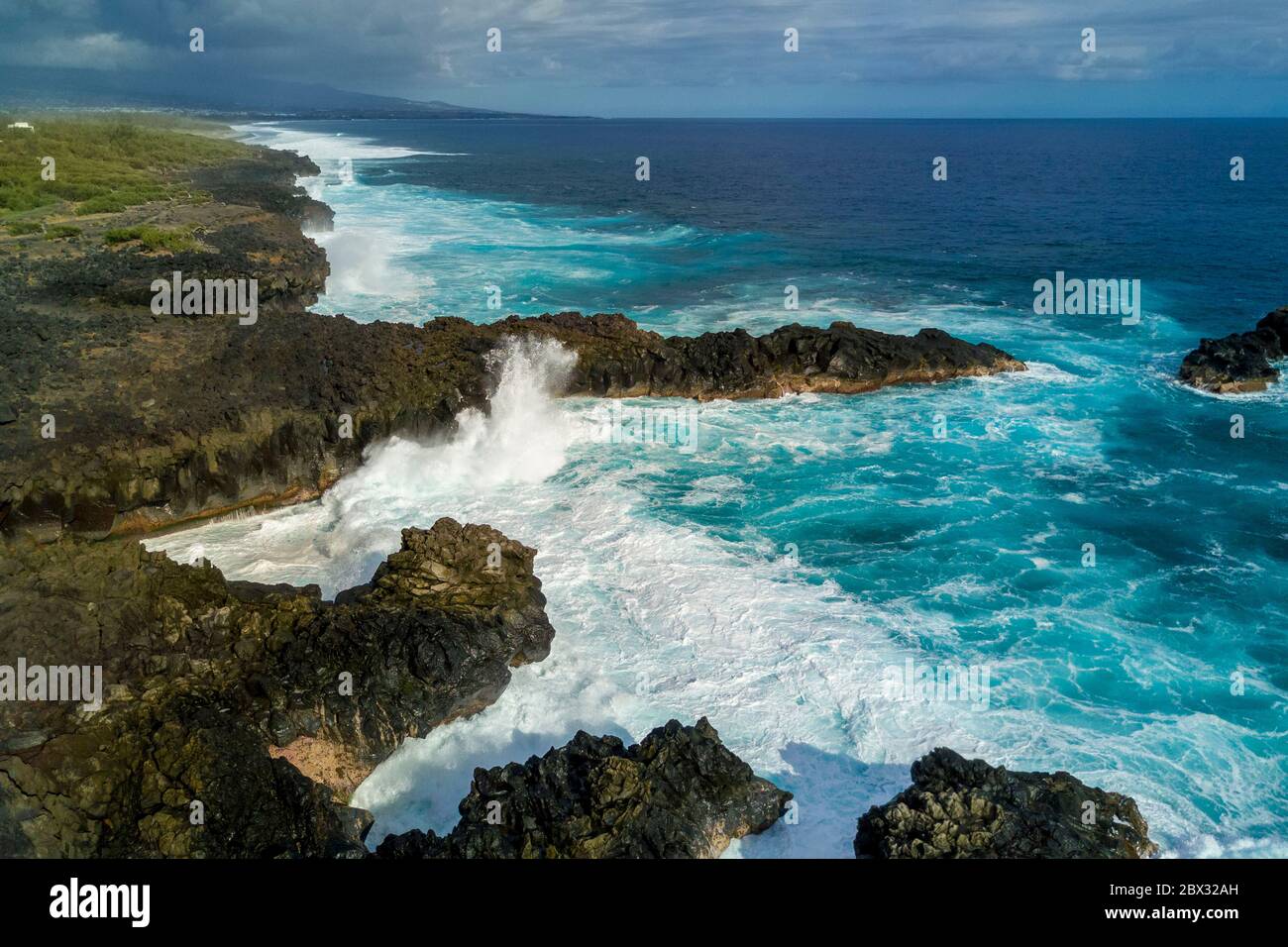 Francia, isola di Reunion (dipartimento francese d'oltremare), l'Etang Salé les Bains, la costa tra le Gouffre e l'Etang du Gol (Stagno di Gol), rocce basaltiche nere di origine vulcanica tormentate dall'oceano (vista aerea) Foto Stock