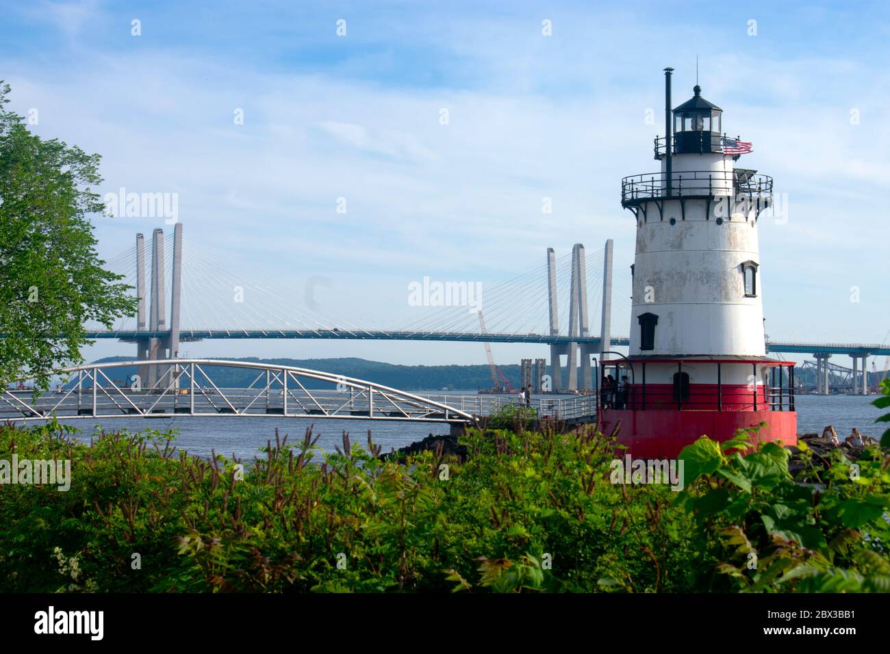 Faro corto, rosso e bianco situato nella contea di Westchester sul fiume Hudson con il ponte Tappan Zee ricostruito sullo sfondo. Foto Stock
