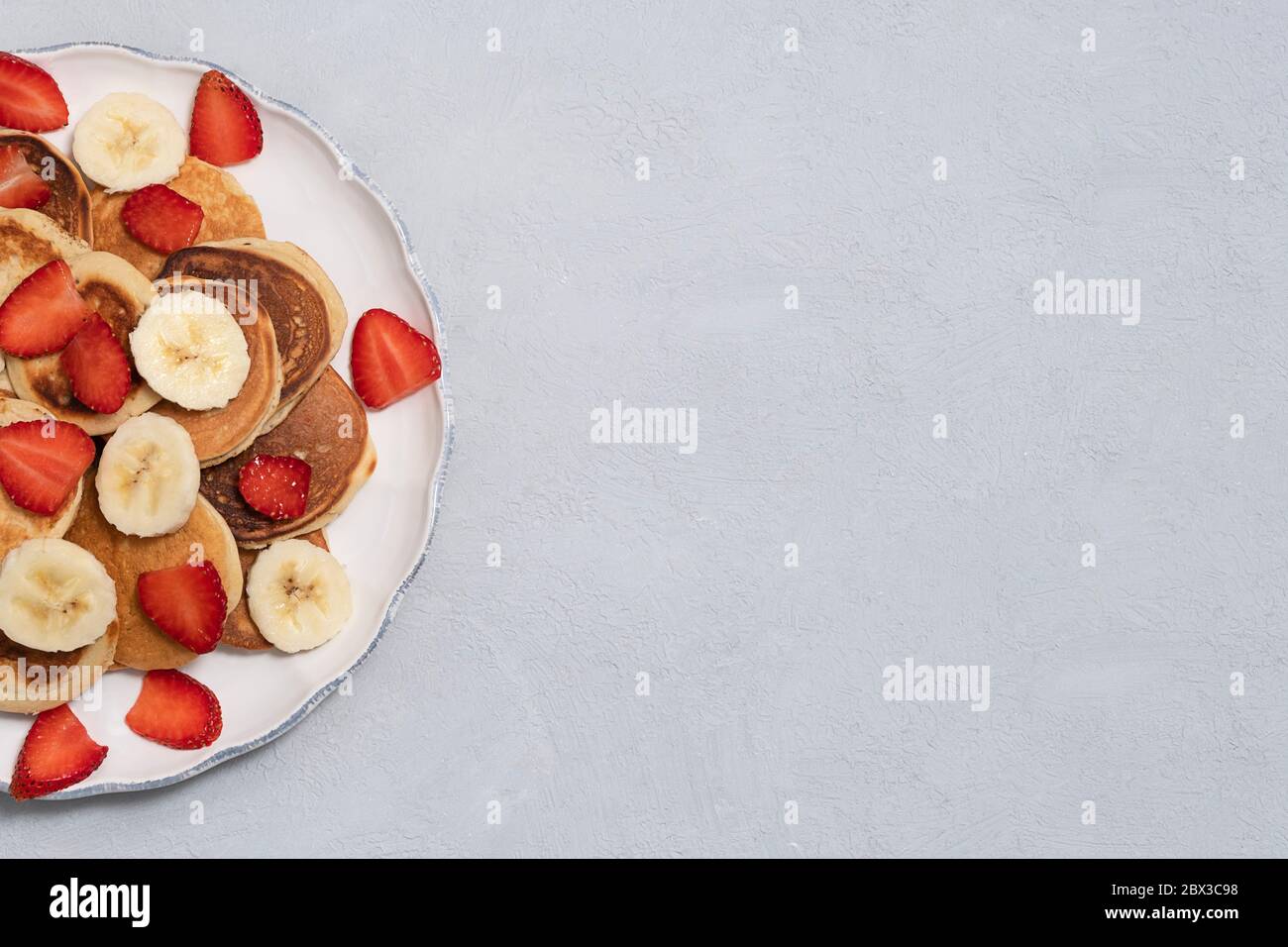 Frittelle fatte in casa su piatto bianco su fondo neutro di cemento. Immagine con spazio di copia, vista dall'alto Foto Stock
