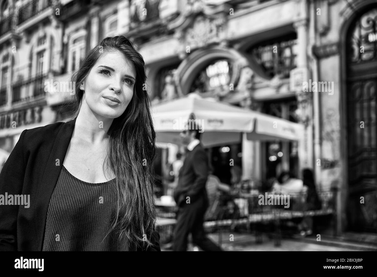 Una donna portoghese si trova fuori dal Café Majestic lungo la Rua de Santa Catarina a Porto, in Portogallo. Foto Stock