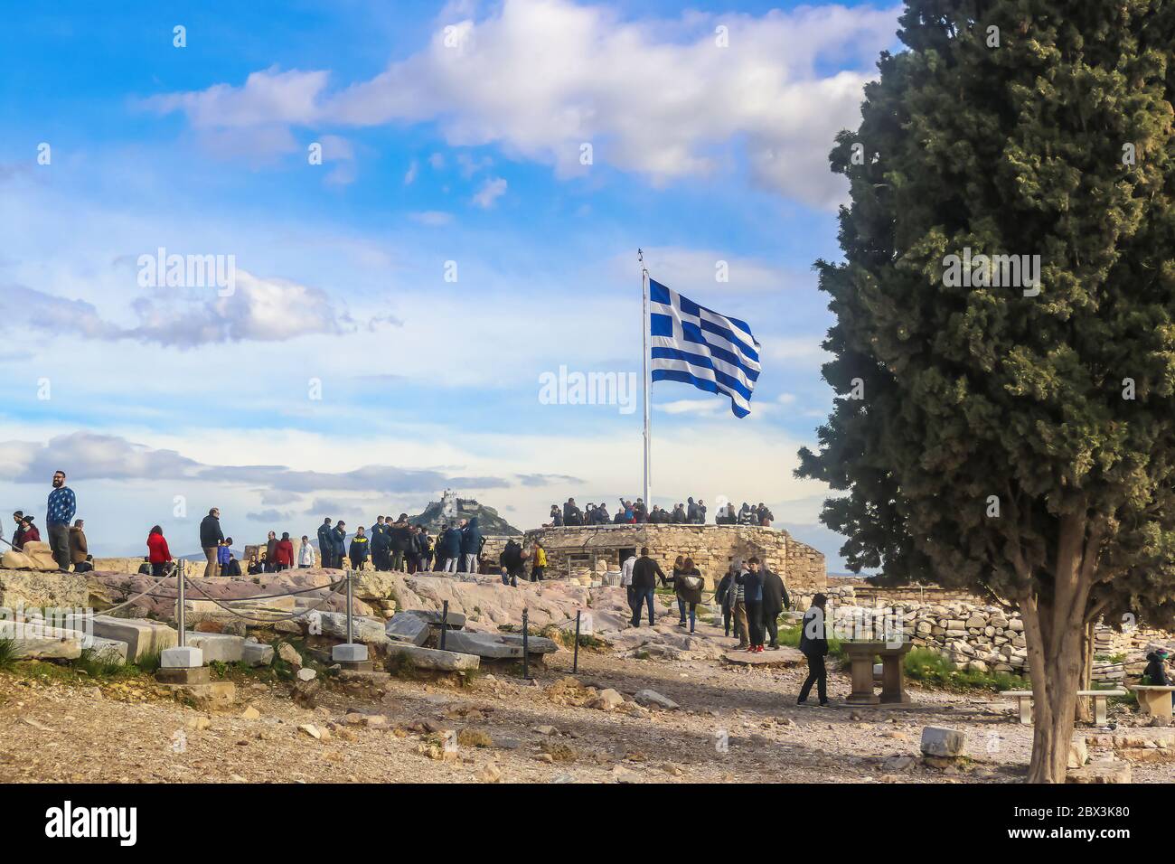 2018 01 03 Atene Grecia - i turisti all'Acropoli di Atene si riuniscono intorno alla bandiera greca scattando foto con la Cappella di San Giorgio su Lykavitto Foto Stock
