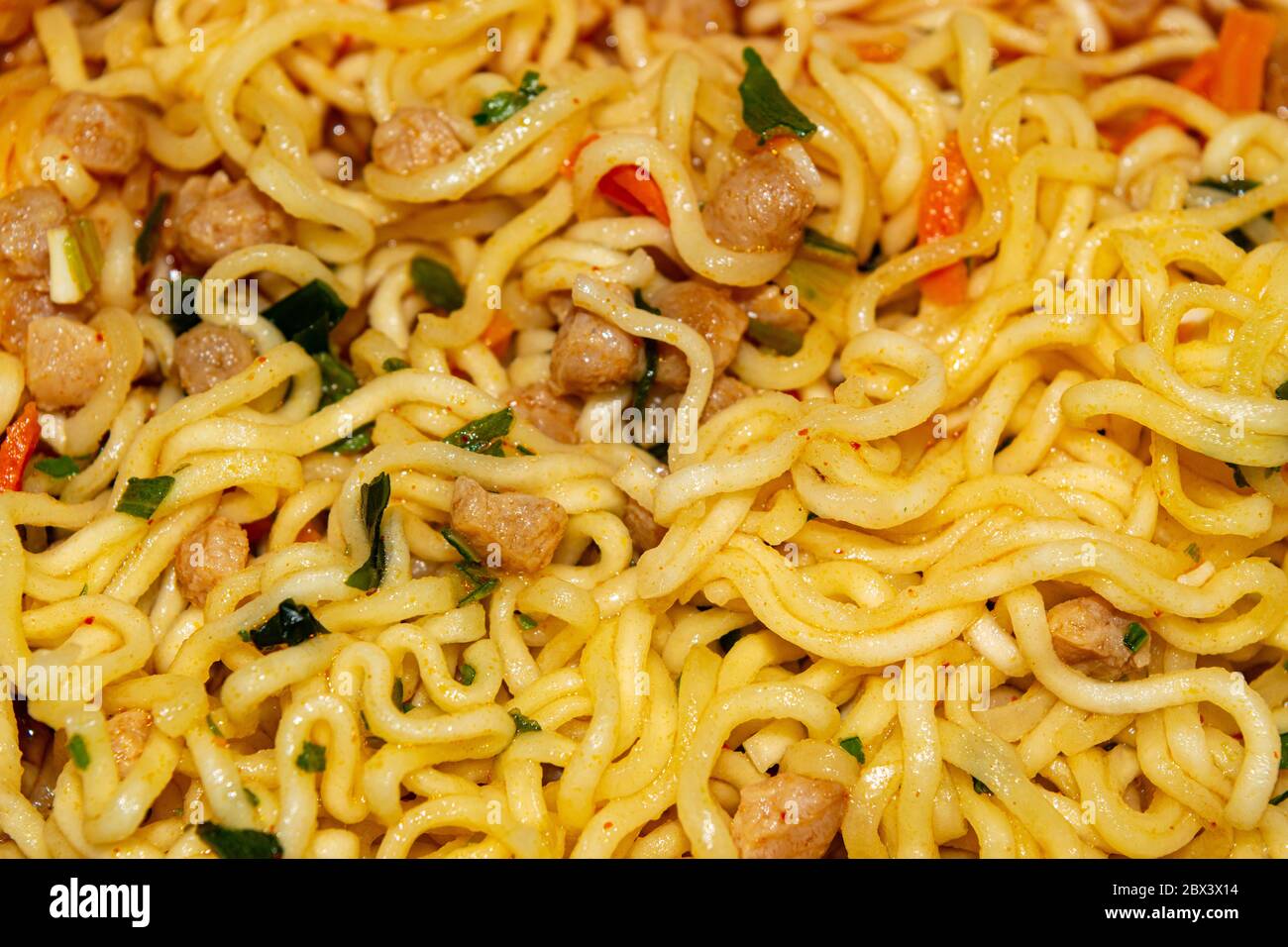 Tagliatelle istantanee cotte con spezie, verdure secche e carne liofilizzata. Primo piano Foto Stock