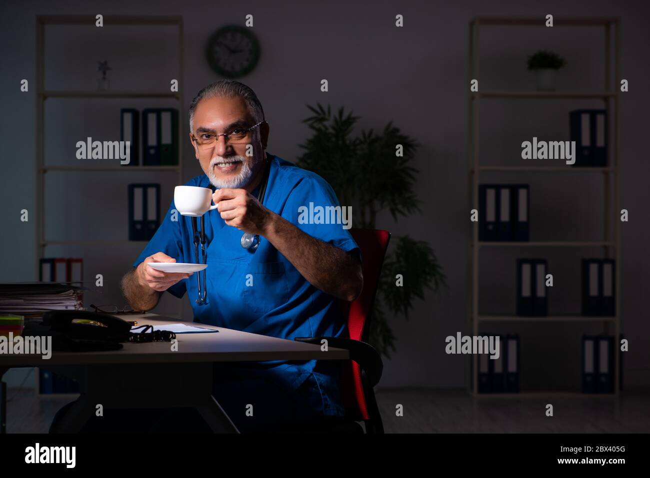 Medico maschile di età in ospedale di notte Foto Stock