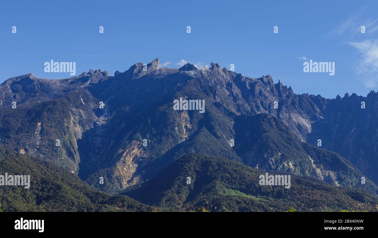 Estrema primo piano del Monte Kinabalu con cielo blu chiaro e nuvola. Il Monte Kinabalu è il picco più alto della gamma dei Crocker del Borneo.-concetto di viaggio Foto Stock