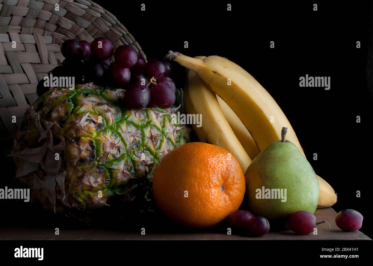 Frutta di Stilllife su un tavolo usando chiaroscuro tecnico, luce di tasto basso, fotografia di cibo scuro Foto Stock