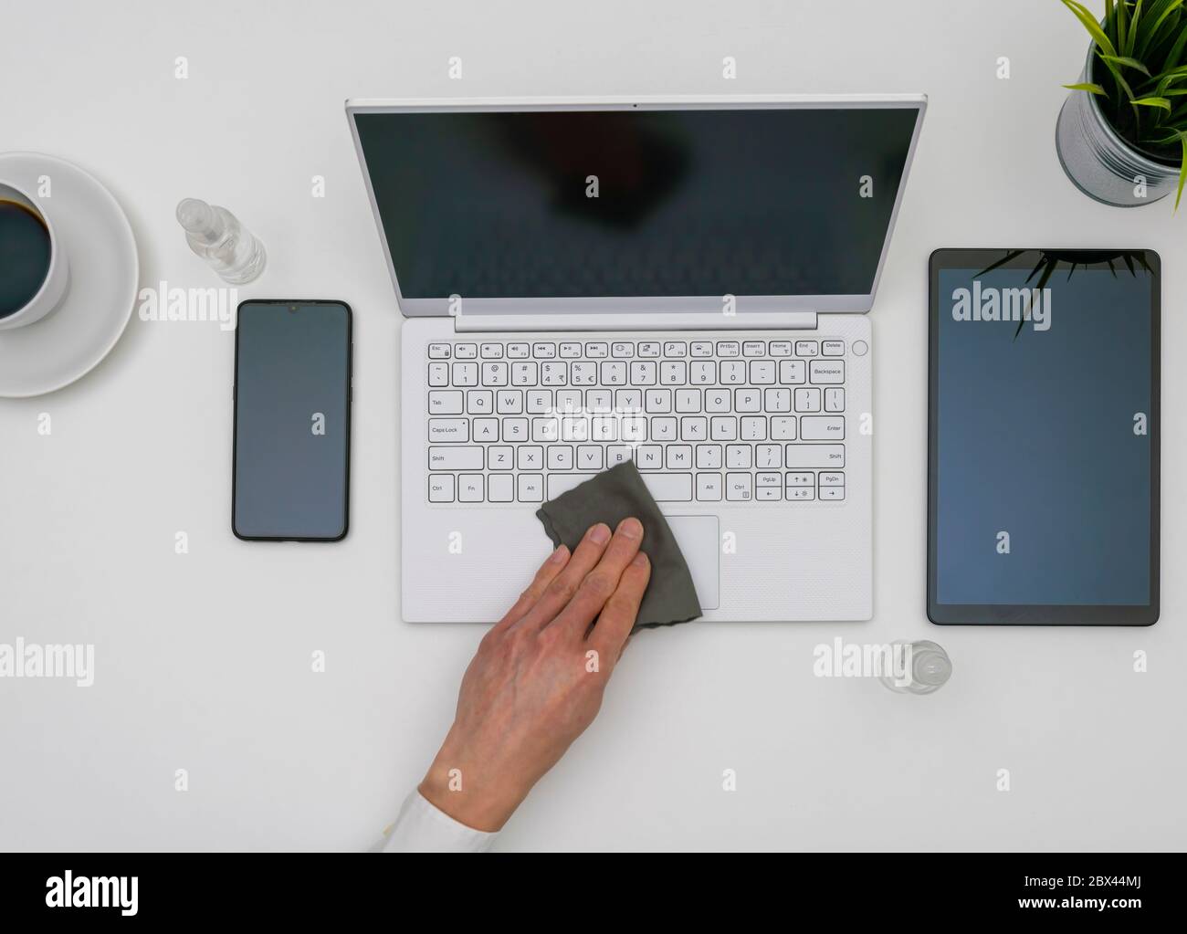 Igienizzazione di un computer portatile in ufficio Foto Stock