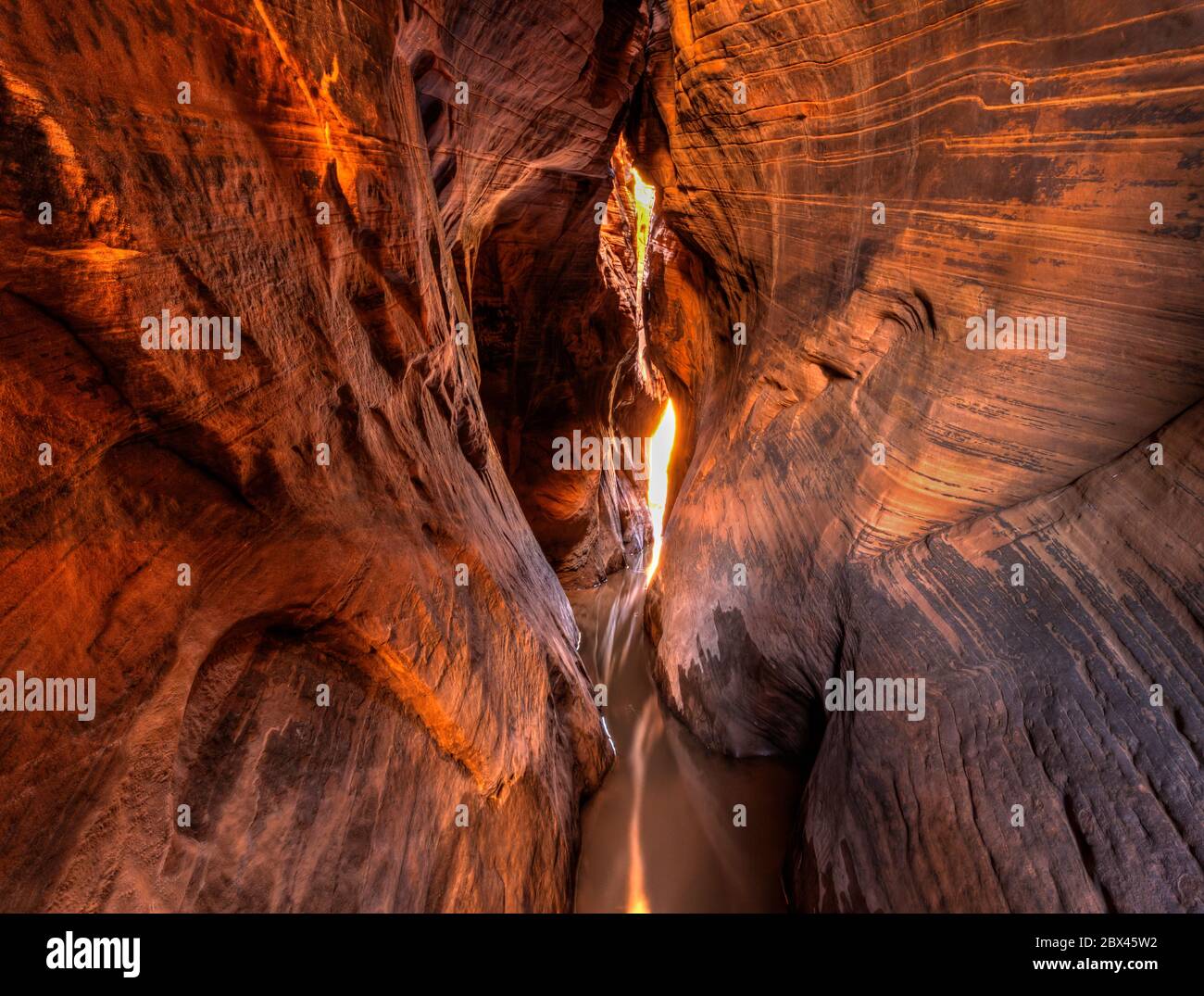 Una lunga esposizione di luce calda e morbida che filtra nel Tunnel slot Canyon nel Grand Staircase-Escalante National Monument nello Utah. Foto Stock