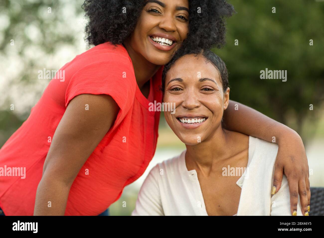 African American madre abbracciando la sua figlia adulta. Foto Stock