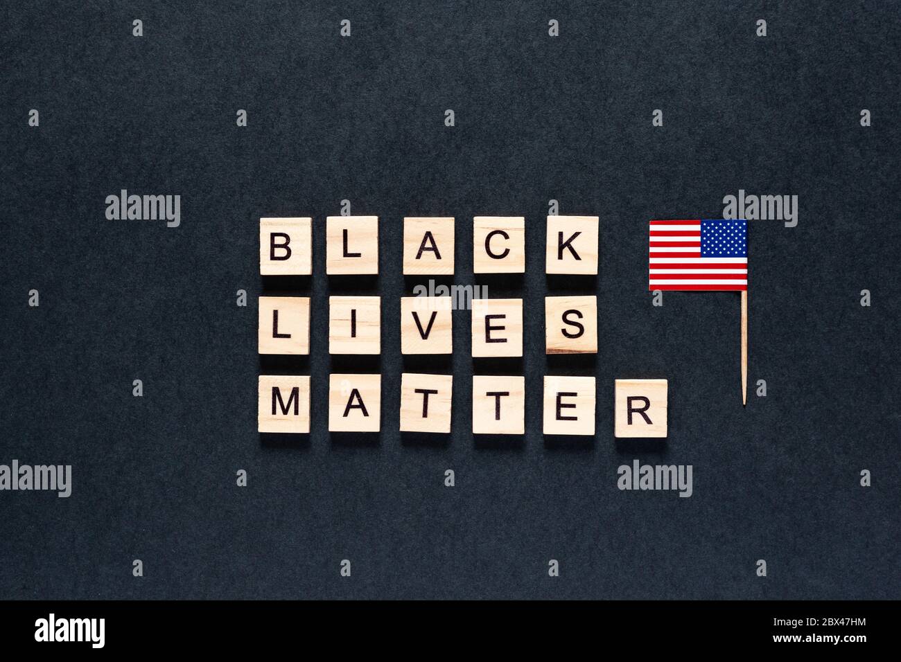 Black Lives Matter iscrizione su sfondo nero. Disordini. Hashtag Blacklivesmatter. Proteste. Bandiera americana. STATI UNITI Foto Stock
