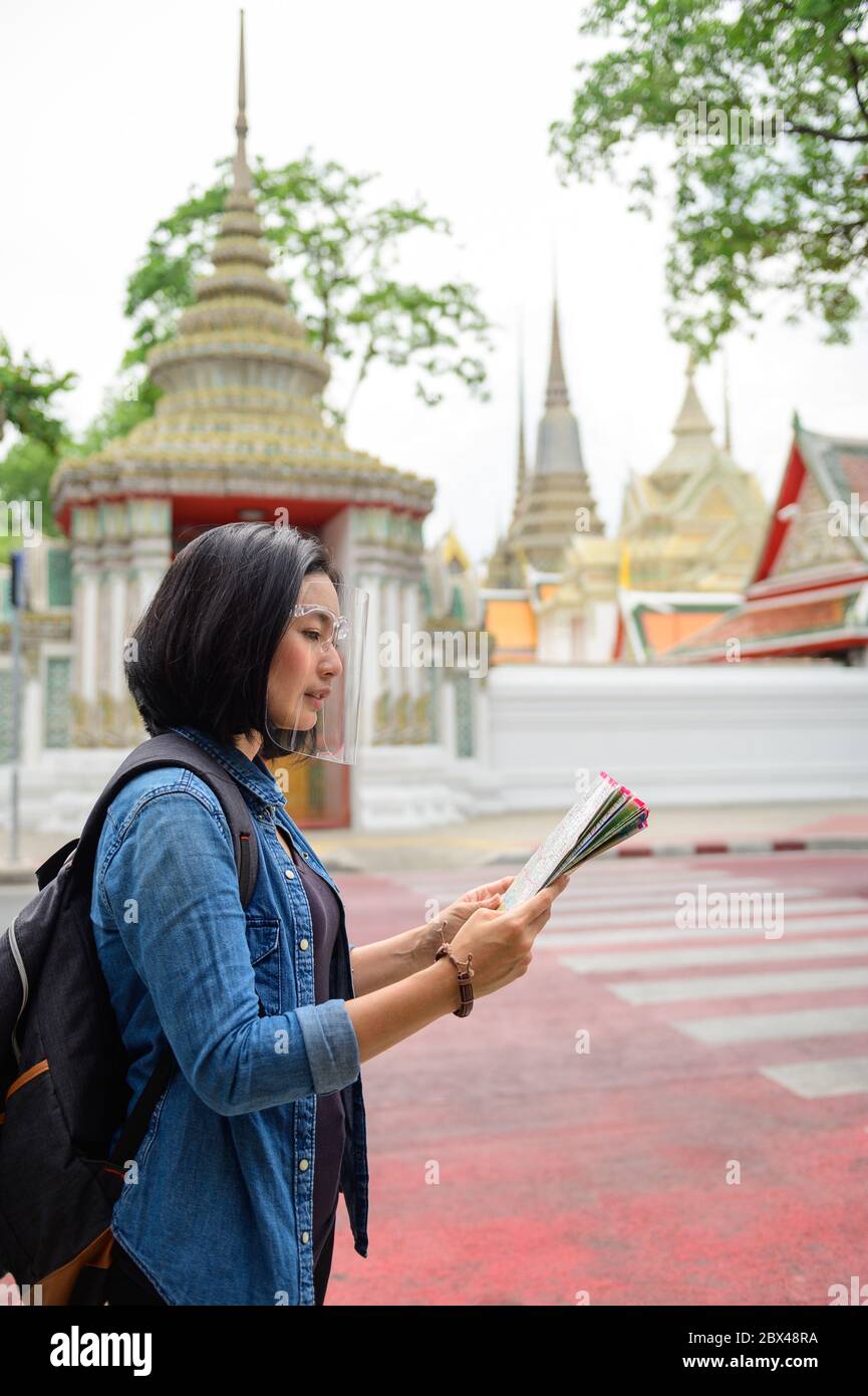 Nuova normalità di donna asiatica che tiene la mappa a Wat Pho, Bangkok Foto Stock