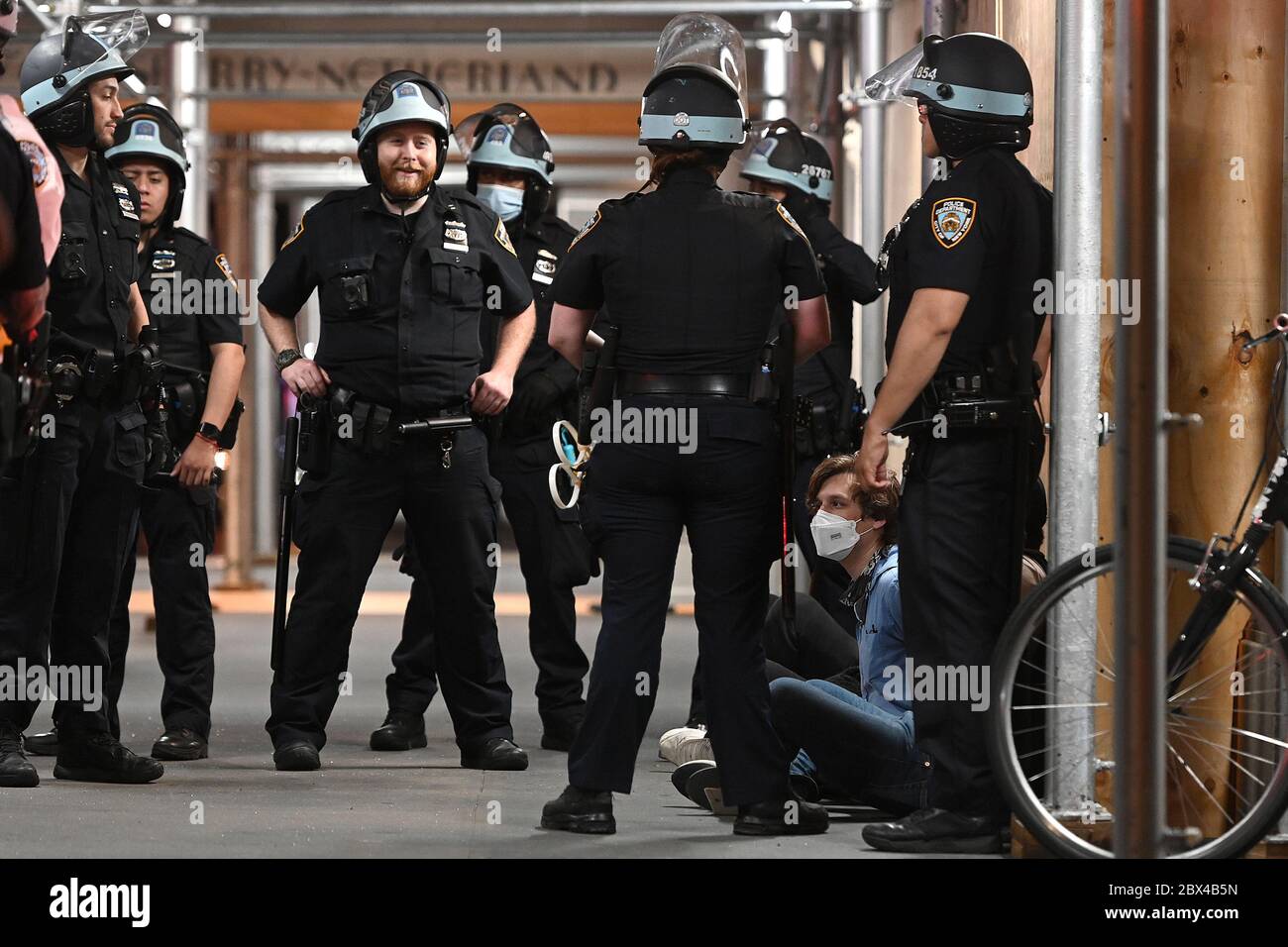 New York City, Stati Uniti. 04giugno 2020. Ufficiali della NYPD in equipaggiamento da sommossa si levano sui manifestanti arrestati sulla Fifth Avenue per aver marciato dopo il coprifuoco, a New York, NY, 4 giugno 2020. New York City ha imposto un 20 a causa di continui saccheggi e saccheggi di negozi durante le proteste per la morte di George Floyd da parte della polizia di Minneapolis il 25 maggio. (Anthony Behar/Sipa USA) Credit: Sipa USA/Alamy Live News Foto Stock