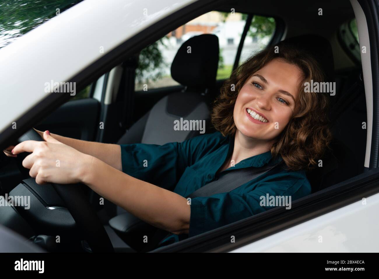 Donna conducente guida un'auto Foto Stock