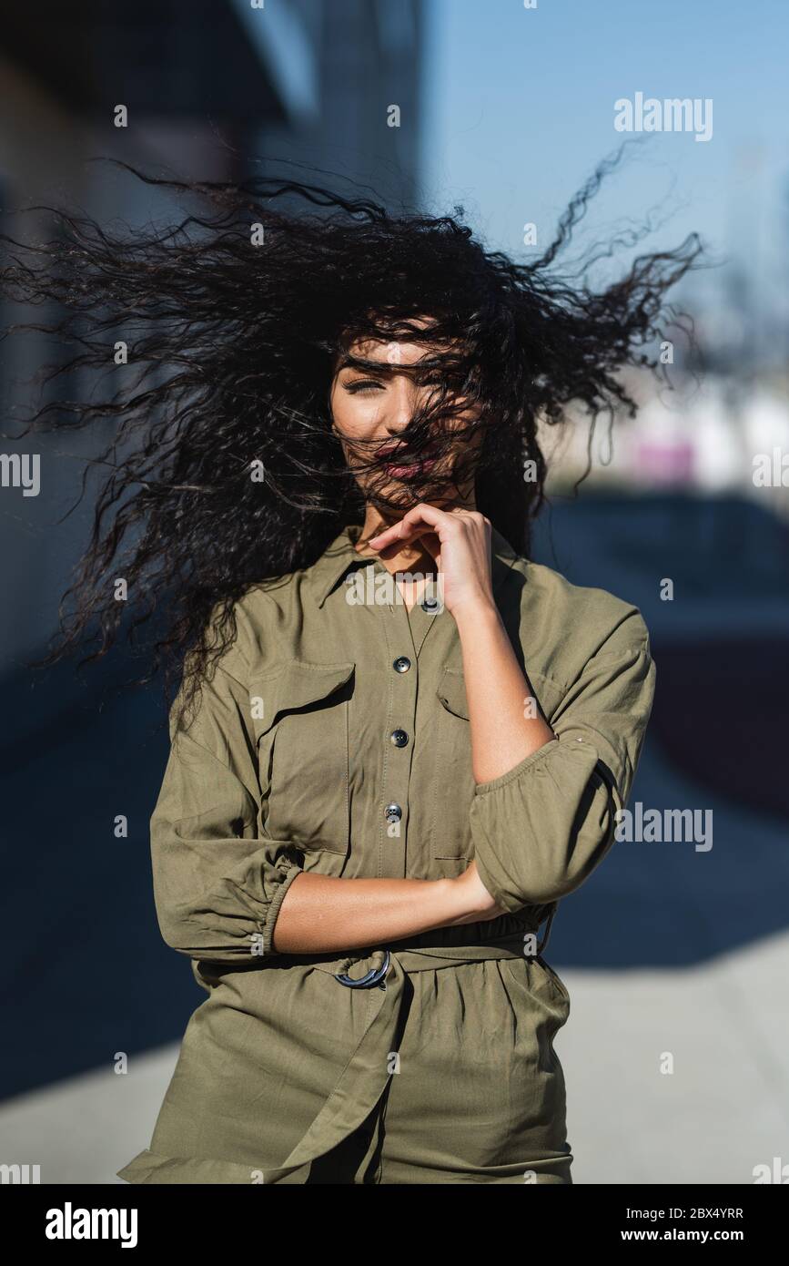 Giovane donna attraente con i suoi capelli ondulati nel vento Foto Stock