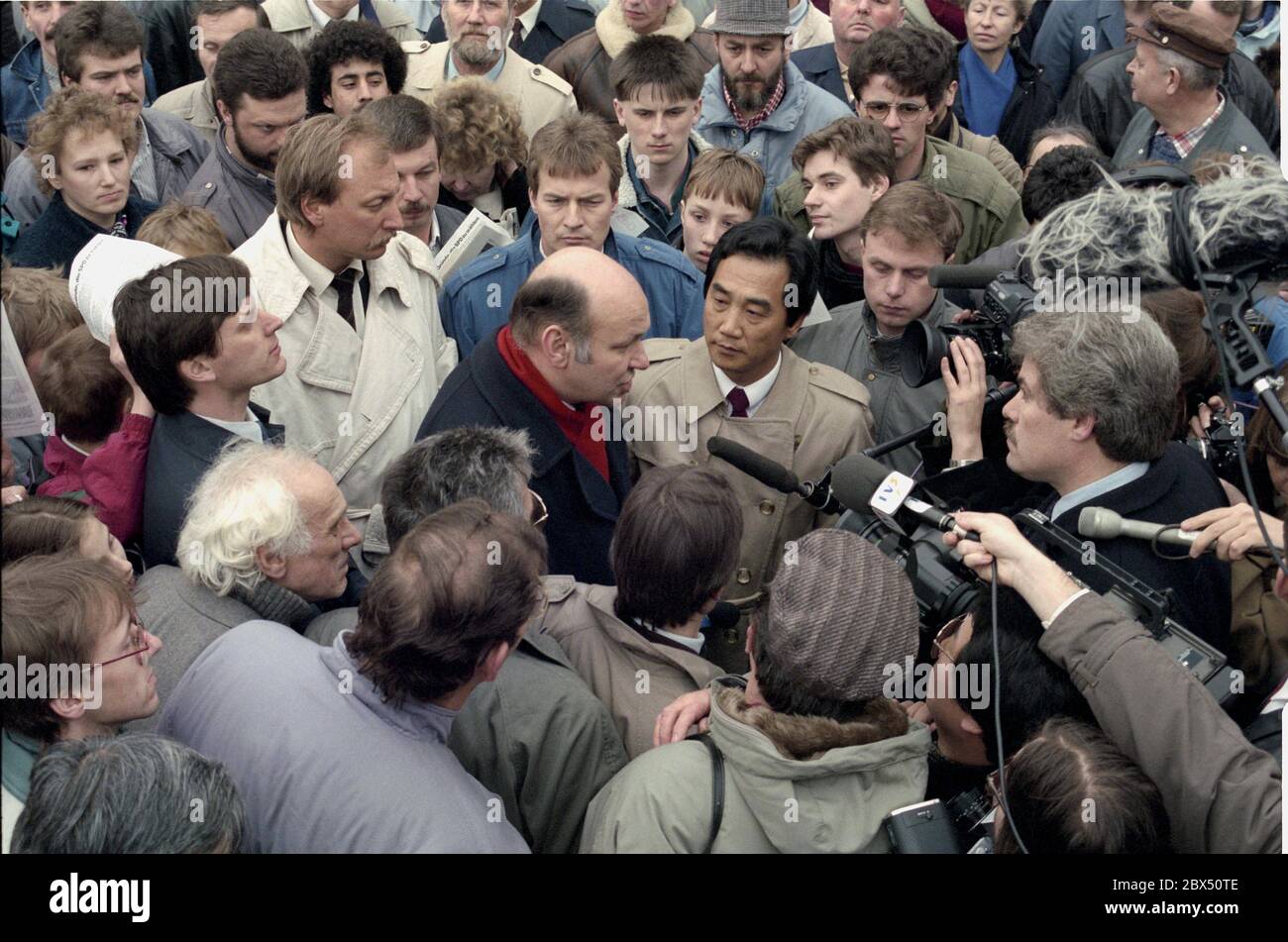 Berlino / RDT / primi 15.3.1990 Sindaco di governo Walter Momper, SPD. SPD incontro ad Alexanderplatz, a Berlino Est, campagna elettorale per le elezioni del Volkskammer in marzo. La popolazione è ansiosa di informazioni, la schiacciamento è grande. Anche tra i giornalisti. Intervista con la televisione giapponese in folla // elezione / folla / 1990 / persone *** Local Caption *** governare Myor Walter Momper, SPD, su Alexanderplatz in Germania orientale (comunista). Normalmente questo è territorio straniero, ma il muro è caduto e le regole della Guerra fredda non sono più valide. Campagna elettorale per il tedesco orientale Foto Stock