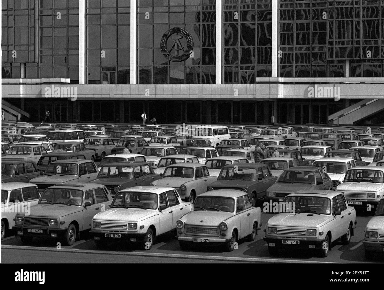 Quartieri di Berlino / fine della DDR / Emblem / 20.2.1985 Berlino Est: Palazzo della Repubblica. C'era anche il Volkskammer. Il simbolo della DDR è ancora appeso. Il parcheggio di fronte mostra la prosperità della DDR. Ci sono stati principalmente solo 2 tipi di auto: Trabant e Wartburg. Il palazzo fu abbattuto dopo l'unificazione. // Stato-RDT / Linden in luogo del palazzo cittadino demolito nel 1950, il Palazzo della Repubblica è stato costruito dal 1973 in poi, 180 m di lunghezza, 32 m di larghezza. All'interno c'erano varie strutture. Gli eventi si sono tenuti nella grande sala, che ha avuto 5000 visitatori. Il Volkskammer della DDR Foto Stock