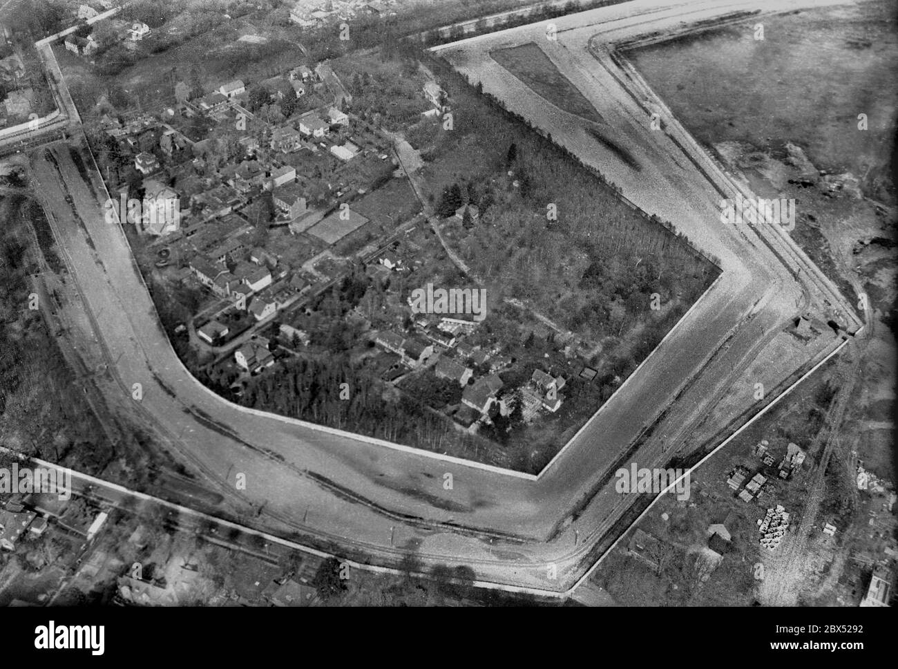 Berlino-Città / DDR / Muro / 30.4.1986 West Berlin village stucco di pietra sul territorio della DDR, quasi interamente circondato dal muro e dalla striscia della morte solo uno stretto passaggio per l'Occidente era aperto. Durante la Guerra fredda, vi vivevano 300 persone. Le pietre sono state considerate un simbolo per le mura di Berlino e il comunismo. La foto è stata scattata da un elicottero militare americano noleggiato da un imprenditore texano. I voli in elicottero sono stati vietati per i tedeschi. Berlino era un territorio occupato alleato. Doveva essere fotografata attraverso una finestra di plastica spessa e sporca. // distretti / Zehlendorf / Storia / Comunismo / Foto Stock