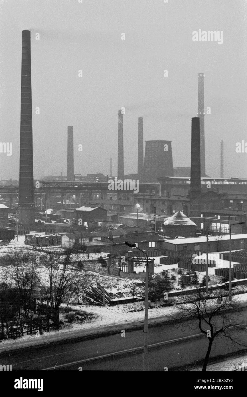 Sassonia-Anhalt / Stato della DDR / inverno / Dicembre 1989 serata invernale a Bitterfeld, m lignite Combine, sito industriale, Ausfall-Strasse // Moodi / economia / fiducia / industria / paesaggio nel 1894 la società Chemische Fabrik Griesheim (Francoforte sul meno) Costruito uno stabilimento a Bitterfeld per la produzione di calce clorurata per elettrolisi. Nel 1900 il processo venne utilizzato anche per estrarre magnesio e alluminio, e nel 1923 Griesheim si trasferì completamente a Bitterfeld. Altre aziende si stabilirono vicino alle miniere di lignite: Agfa costruì una fabbrica di pittura e di film. Nel 1990 arrivò la fine. Il VEB Chemiekombinat ancora Foto Stock