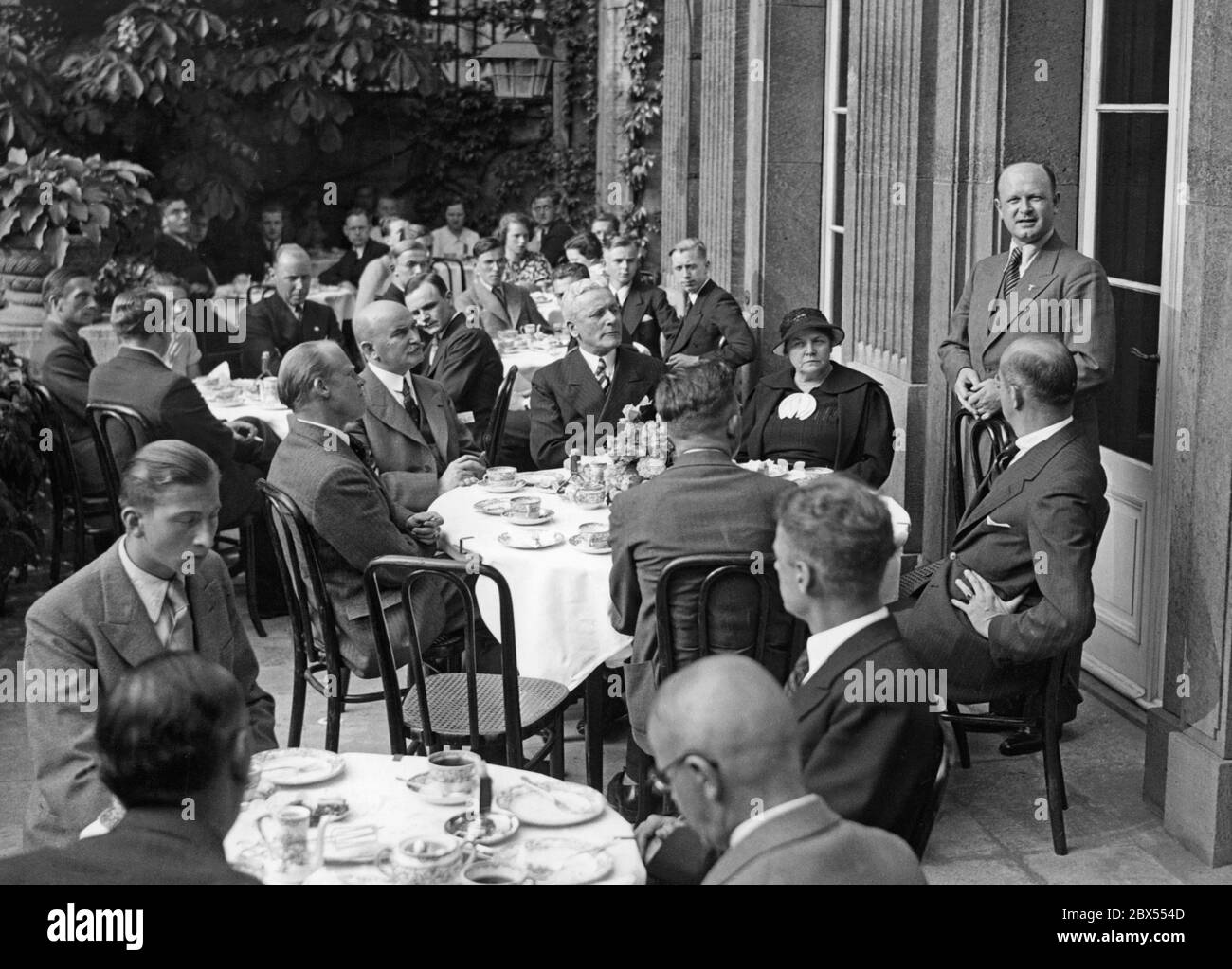 Cerimonia di congedo per gli studenti di scambio della Carl Schurz Society in America. Il Vice Presidente Dr. Draeger parla all'esterno degli studenti di scambio seduti a tavole rotonde. Foto Stock