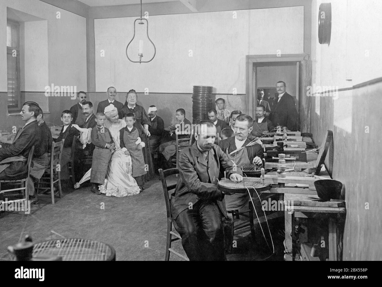 La regina Elisabetta visita una casa per i ciechi a Bucarest, che ha fondato. Le sedie sono tessute là. Regina Elisabetta Bowes-Lyon (in abito bianco) e il direttore dell'Istituto per i ciechi, R. Monske (alla porta). Foto Stock