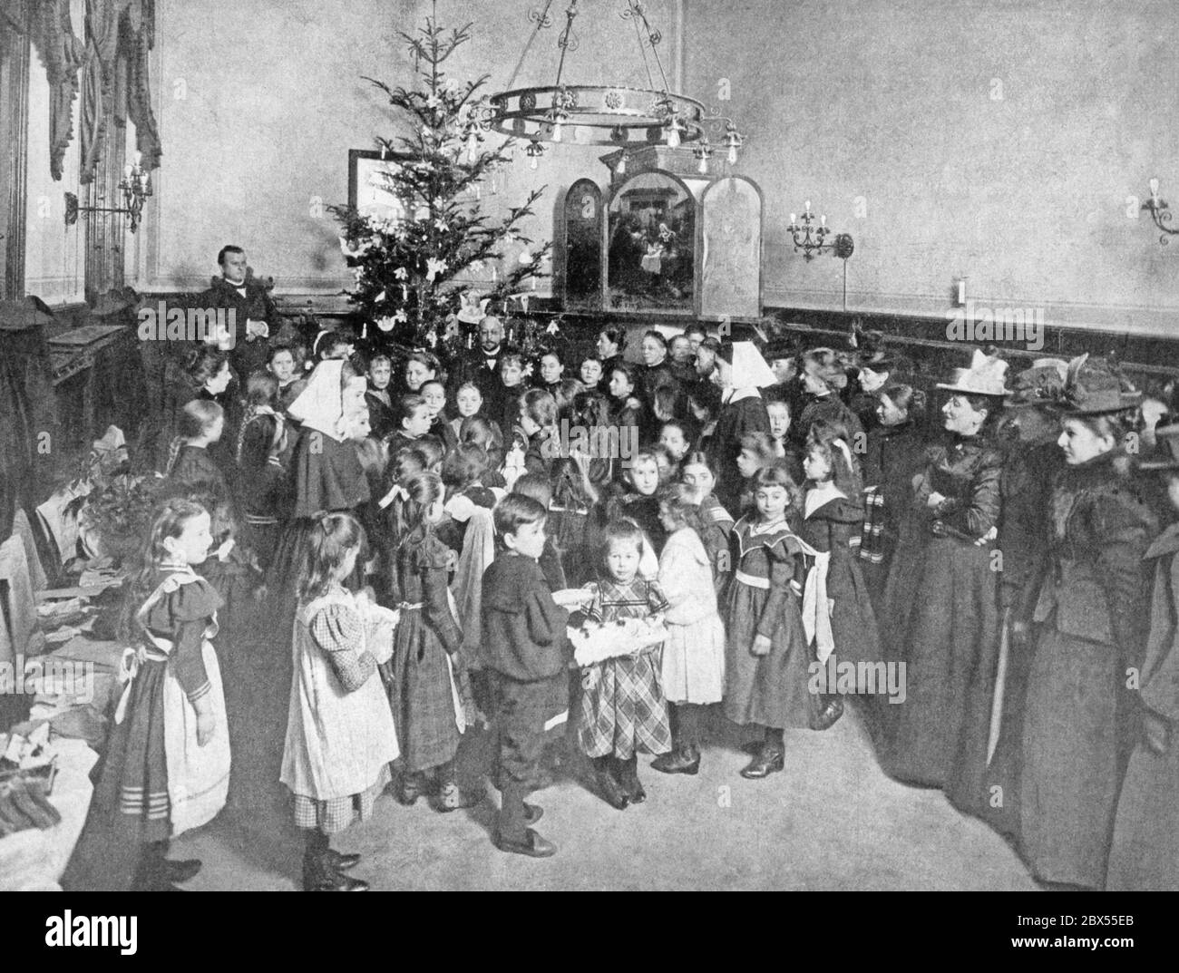 I regali di Natale vengono consegnati ai poveri bambini della città di Berlino dalle suore protestanti deaconess in una canonica della Chiesa protestante. Foto Stock