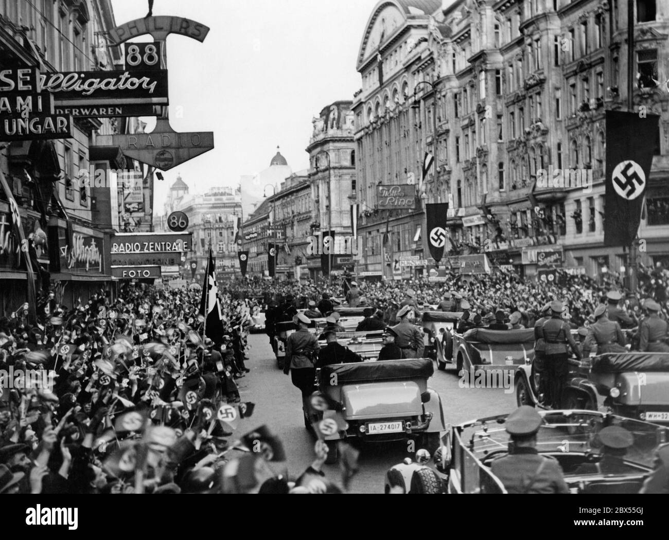 Adolf Hitler in piedi nella prima macchina al suo arrivo a Vienna. Annuncia l'annessione dell'Austria al Reich tedesco di Vienna. Foto Stock