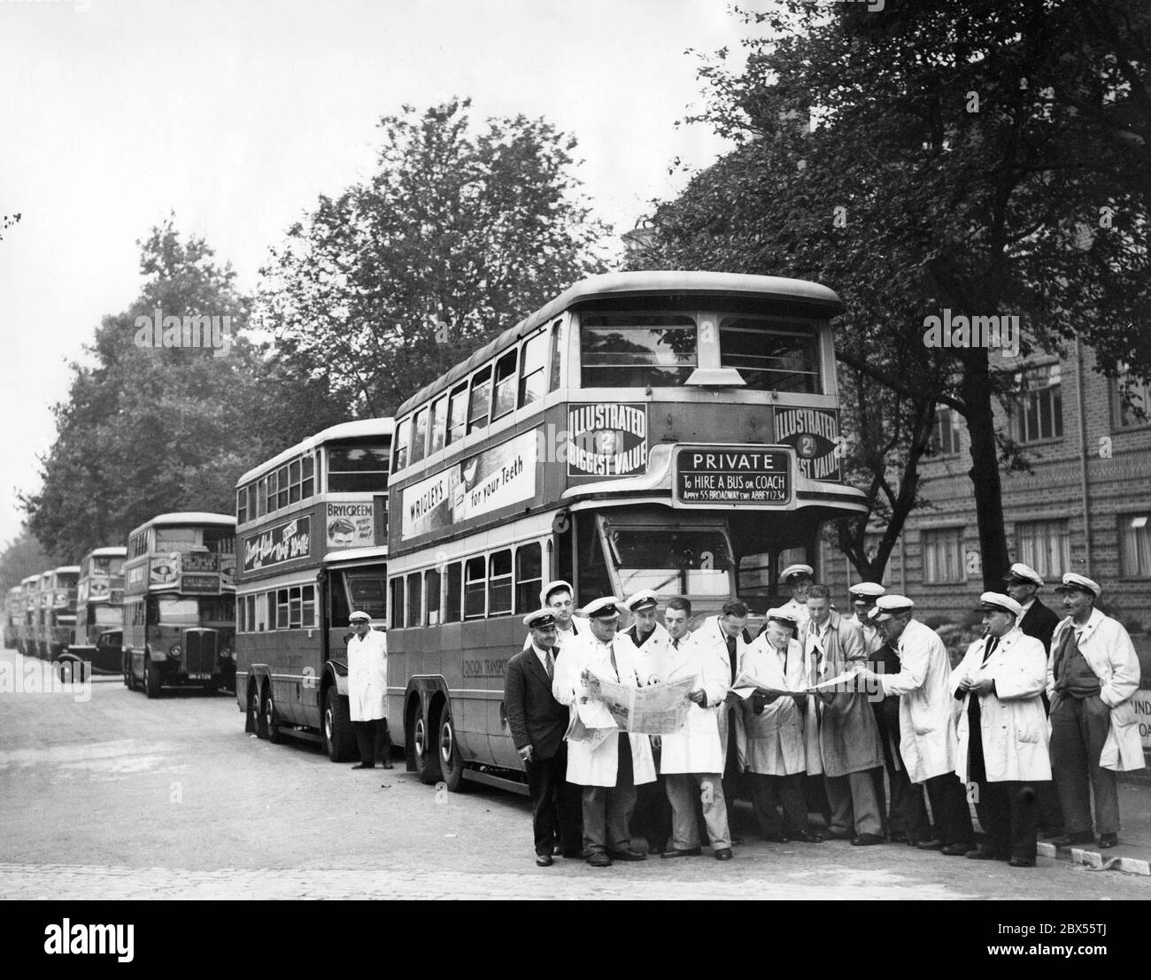 Gli autisti degli autobus discutono degli eventi in corso alla fine dell'estate del 1939 accanto ai loro autobus, che sono stati portati fuori servizio regolare due giorni fa, per poter trasportare soldati in caso di attacco. Foto Stock