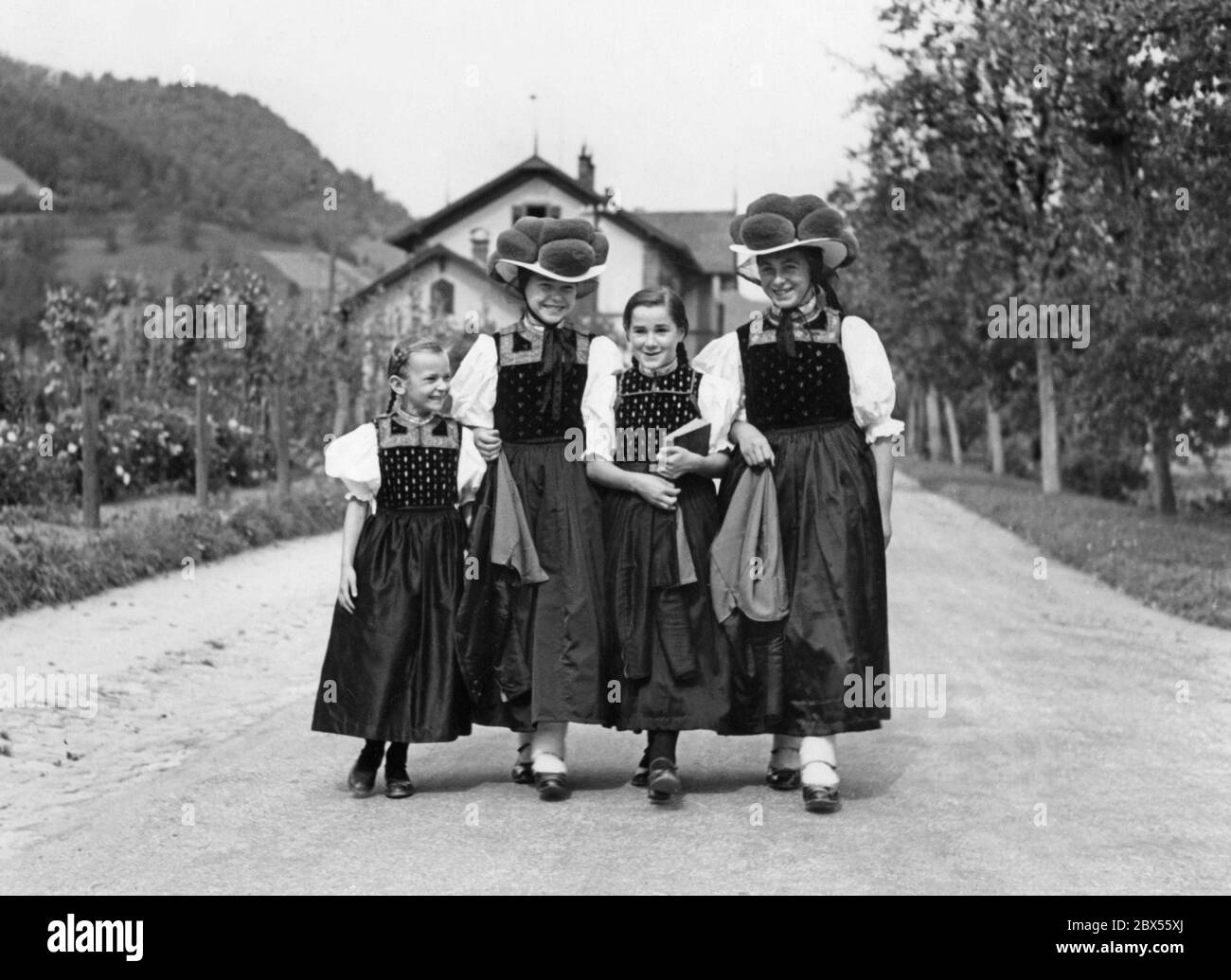 Quattro ragazze della Valle di Gutach nella Foresta Nera in costumi tradizionali, le due più anziane indossano Bollenhut (un headdress formale). Questa foto è stata probabilmente scattata negli anni trenta. Foto Stock