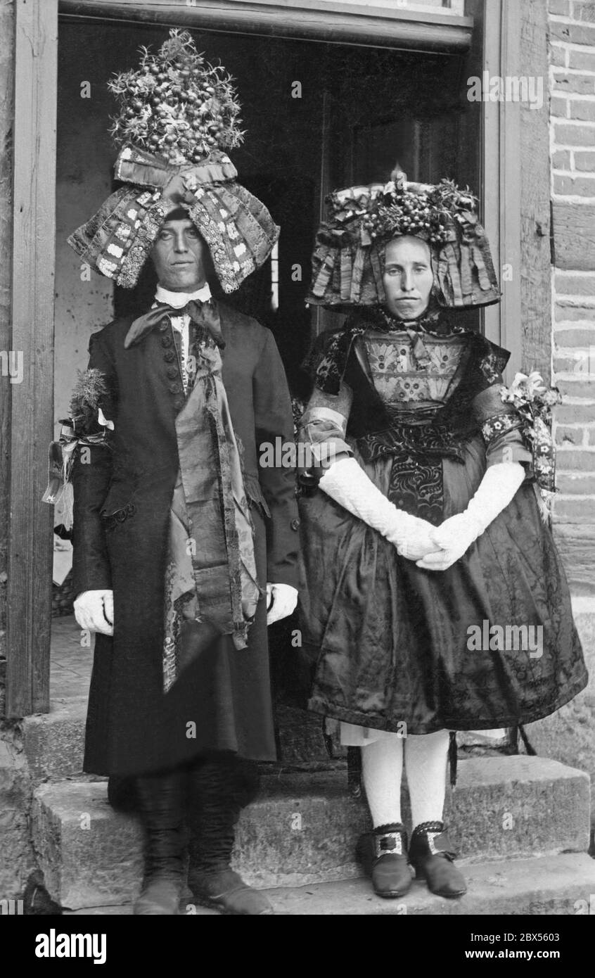 Questa coppia nuziale della regione di Schwalm (Nord Hesse) indossa costumi tradizionali folk tipici di questa zona. L'uomo indossa un cappello da sposo con il 'Lust', un'headdress fatta di marmi e tallonetti di vetro colorati. La donna indossa anche un cappello (un'orlata di tindel) e indossa una gonna in espansione. Foto Stock