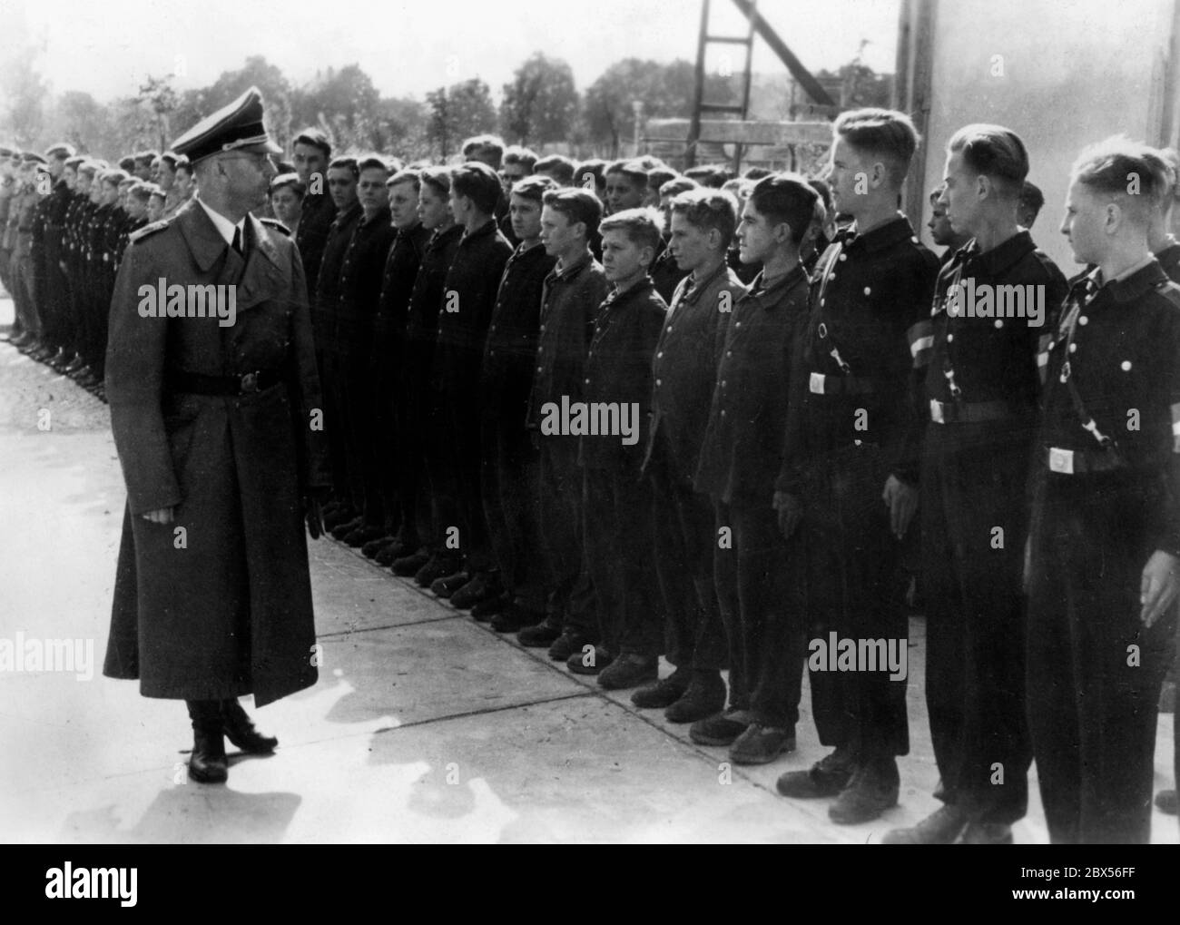 Heinrich Himmler visita una fabbrica del Waffen-SS per fornire informazioni su alcune specialità tecniche, qui di fronte agli apprendisti dell'istituto. Foto Stock