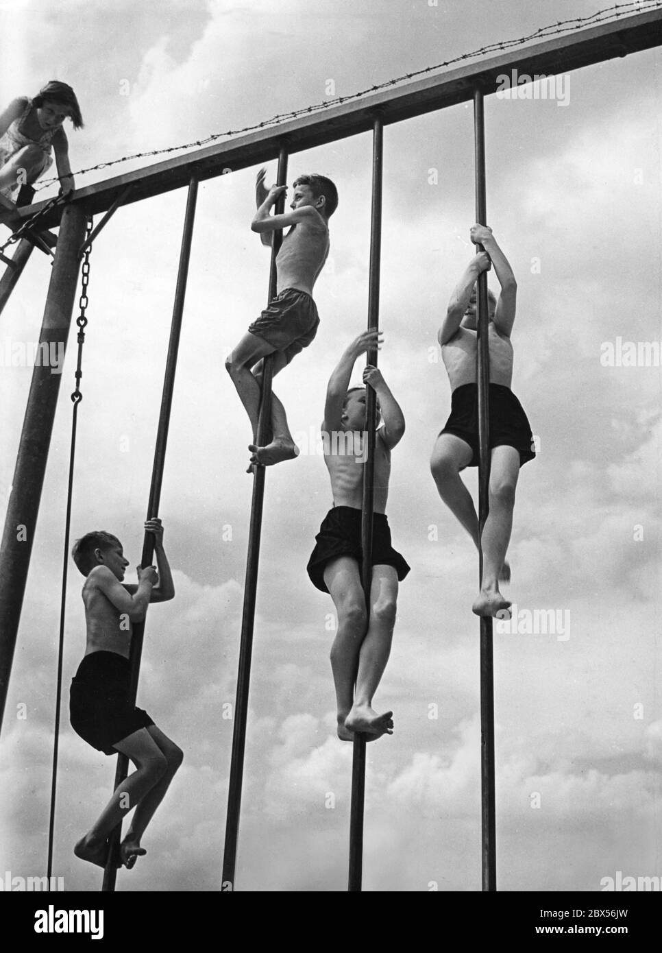 A Strandbad Wannsee, la destinazione di vacanza di coloro che soggiornano a casa, i ragazzi gareggiano su pali sul campo sportivo. Foto Stock