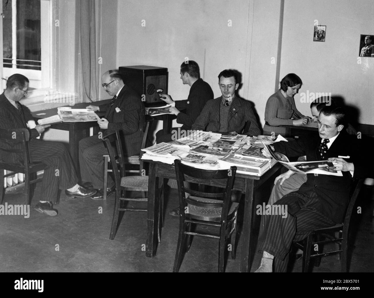 La sala lettura con giornali e Volksempfatenger della casa appena inaugurata per gli emigranti di ritorno gestito dalla NSDAP organizzazione straniera nell'ex Kurhaus Tegel sul lago Tegel. Foto Stock