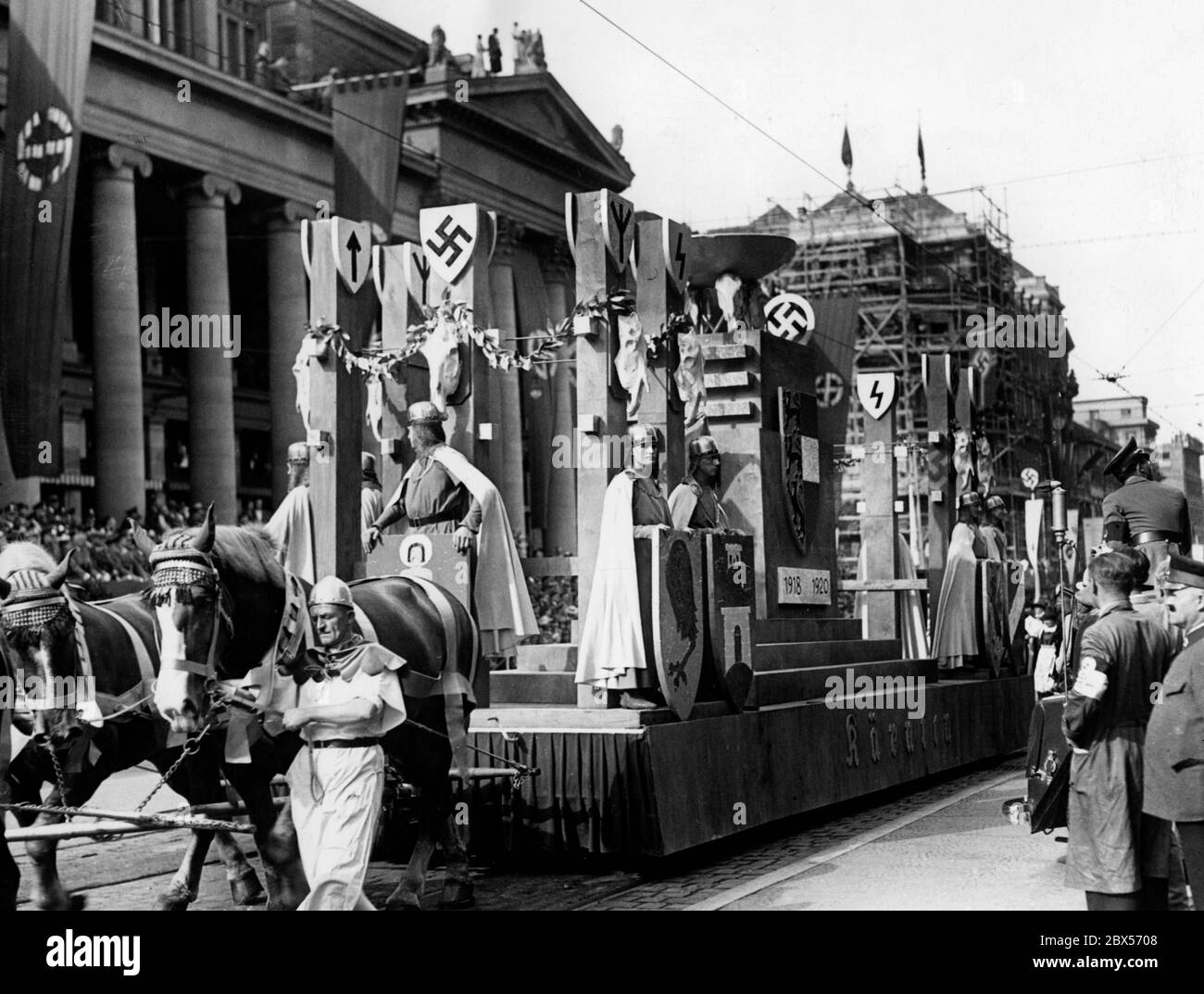 Vista della processione in occasione del congresso dell'organizzazione straniera della NSDAP a Stoccarda. La foto mostra la carrozza della Carinzia Gau, che dovrebbe ricordare la lotta di difesa della Carinzia negli anni 1918-1920. I partecipanti sono vestiti di corazza del cavaliere per questa occasione. All'esterno sono visibili diverse rune, tra cui Tiwaz, Siegrune ed Elhaz. Foto Stock