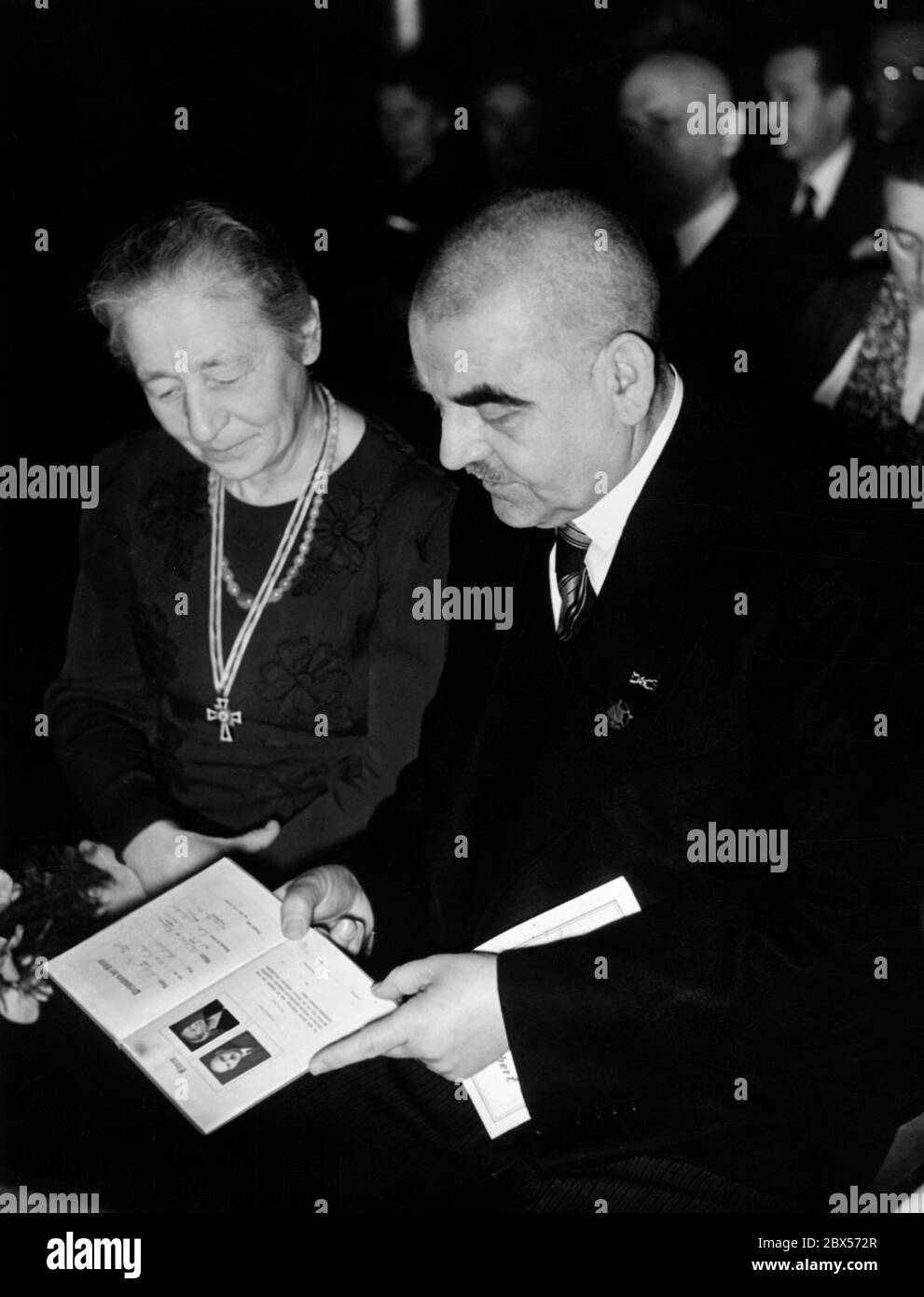 Un membro dell'Unione delle grandi famiglie del Reich (Reichsbund der Kinderreichen) guarda un libro d'onore appena ricevuto a Kaffee Leon a Lehniner Platz a Charlottenburg, che è stato consegnato loro dal leader del Distretto 2 del NSDAP, Meyer. La donna porta la Croce d'onore della Madre tedesca (Mutterkreuz). Foto Stock