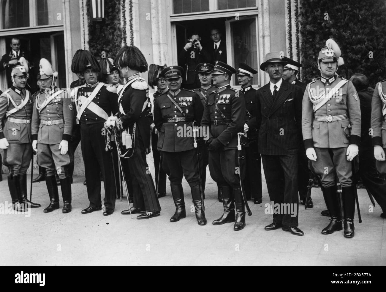 Dopo la presentazione di 23 nuove bandiere di polizia sul Deutschherrnwiese, si svolge una marcia di formazioni di polizia davanti all'Hotel Deutscher Hof, quartiere di Hitler. Durante il passato di marzo, si possono vedere funzionari di polizia stranieri venuti a Norimberga come ospiti d'onore del Congresso del Partito Reich. Nella finestra c'è un fotografo. Foto Stock