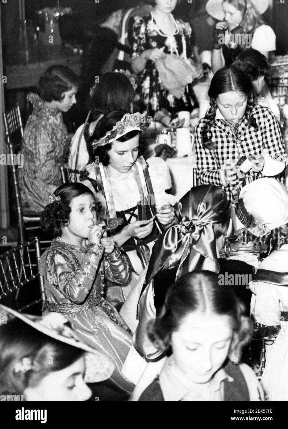 Principessa Margaret (davanti a sinistra, con corno) con sua sorella Principessa Elisabetta ( dietro, a sinistra) durante un carnevale a Londra. Foto Stock